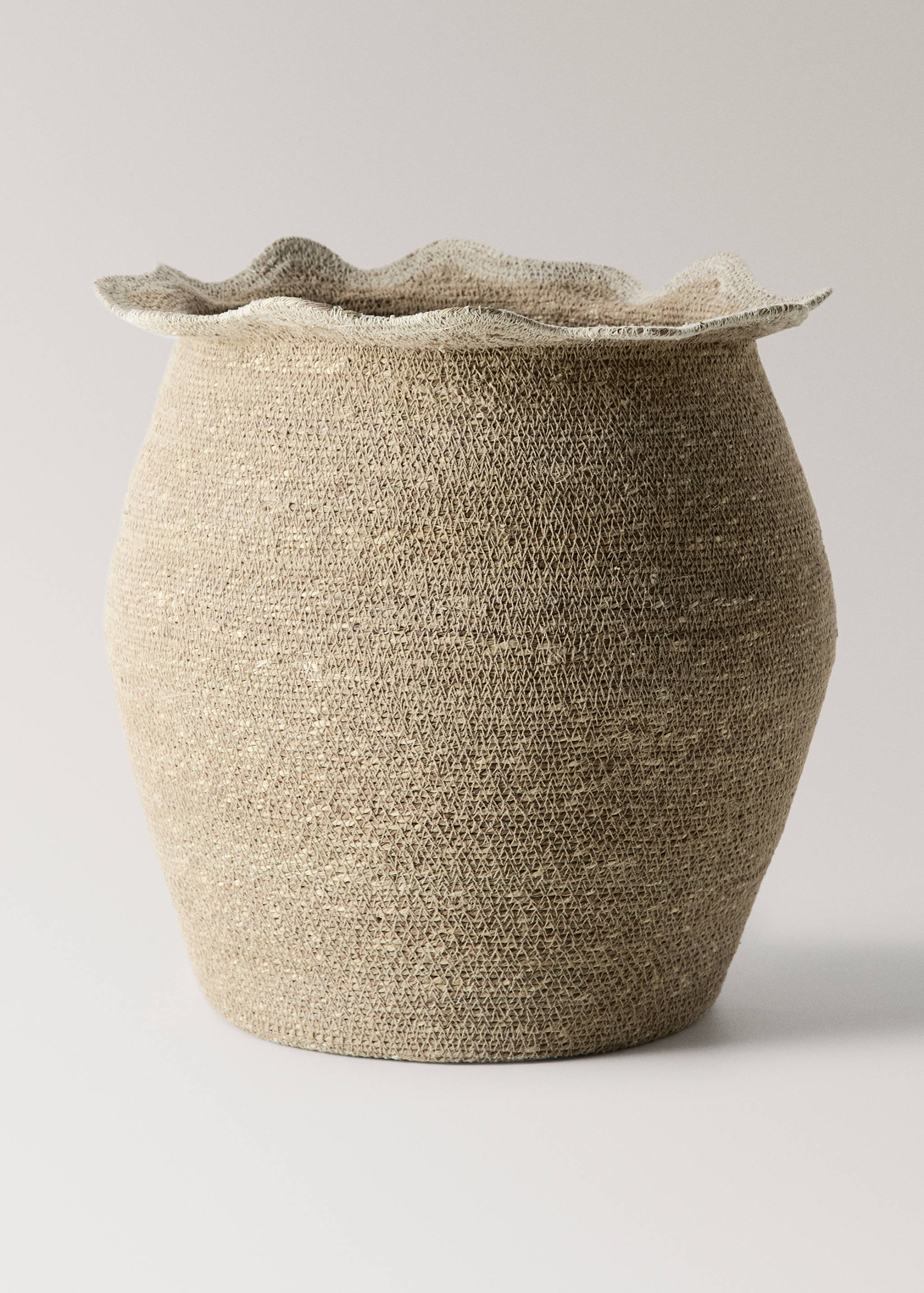 Natural woven basket with a textured, rounded body and a wide, ruffled rim.