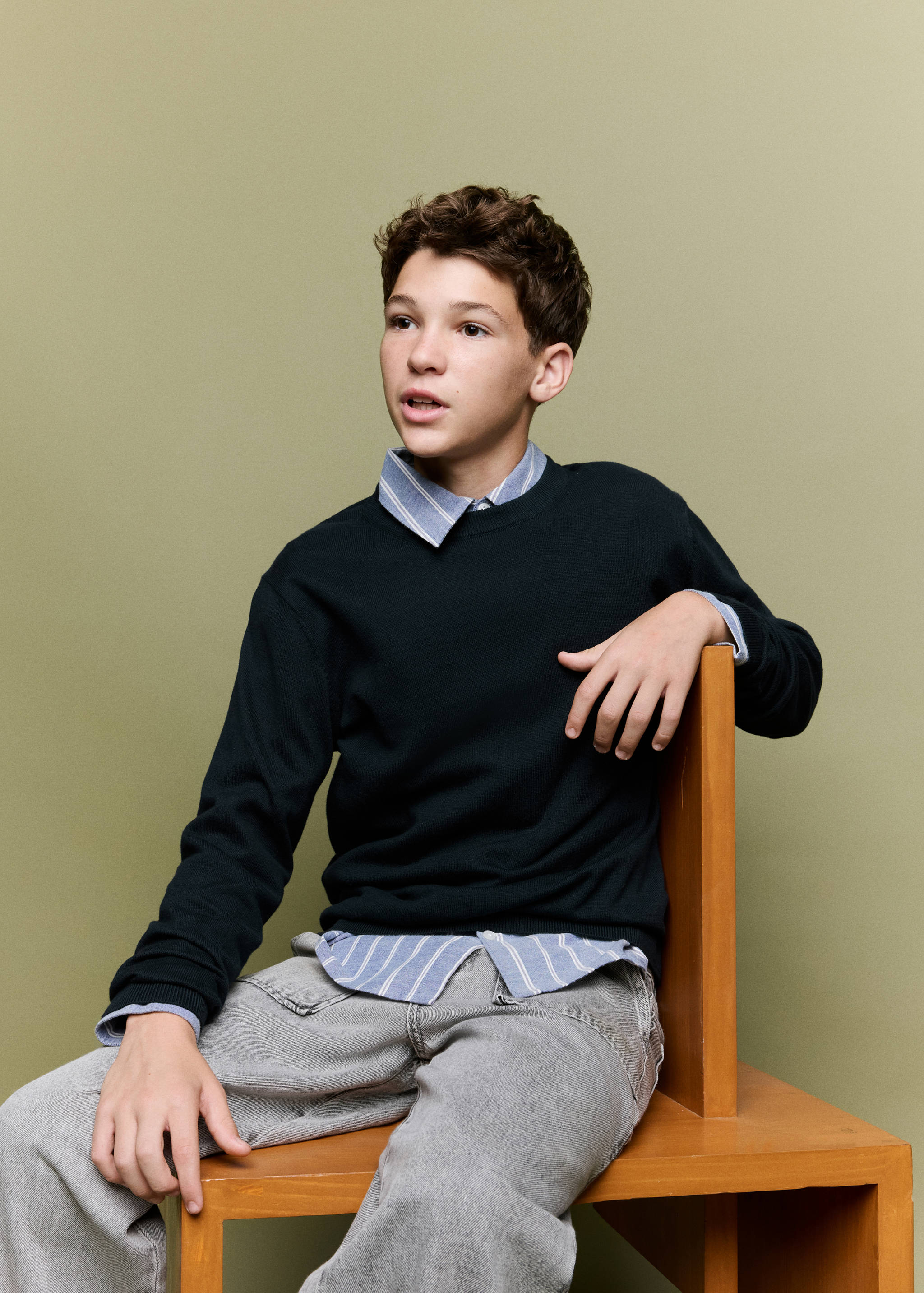 Dark navy-blue crew-neck jersey layered over a striped shirt.
