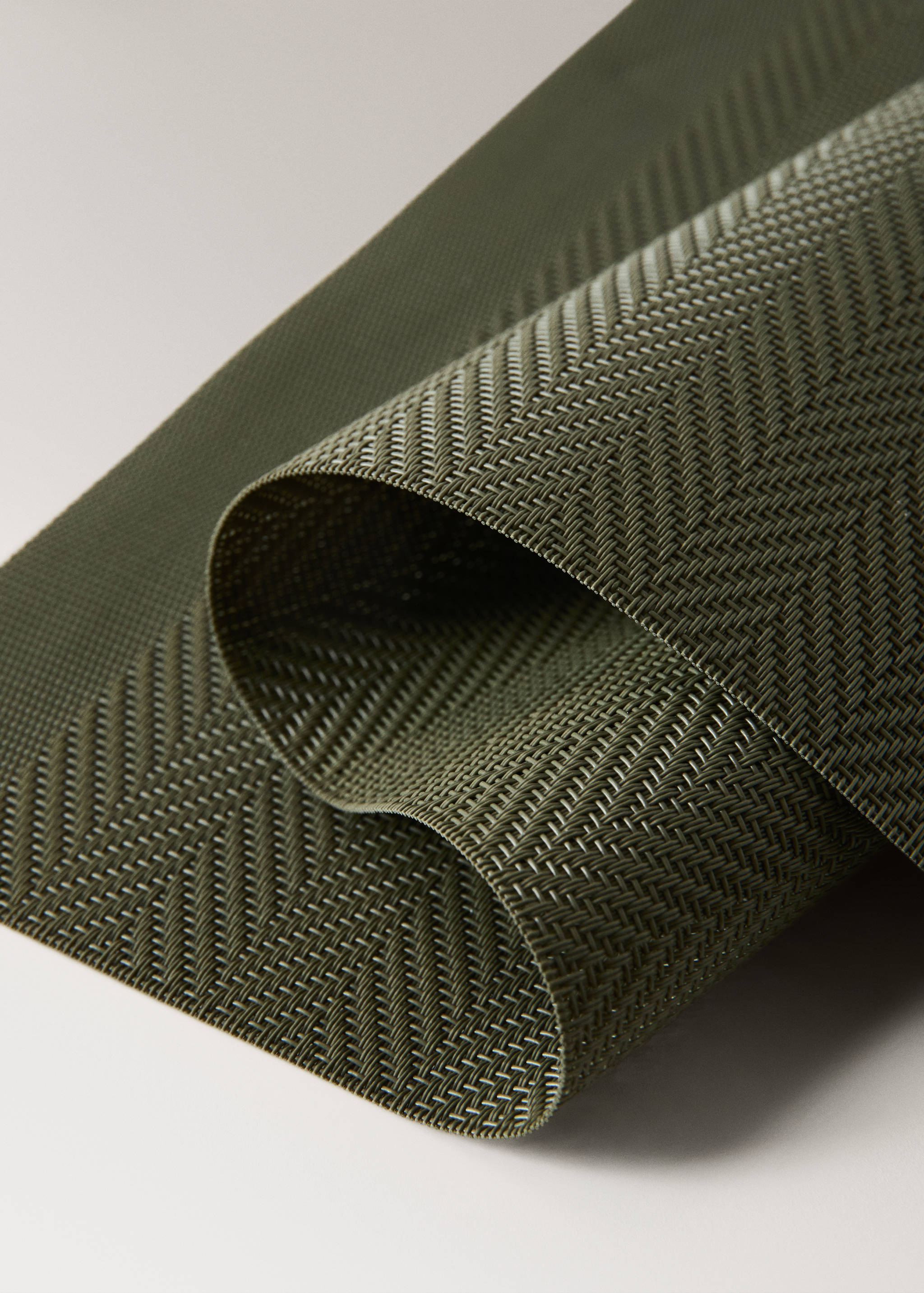 Green individual placemat with a woven herringbone texture.