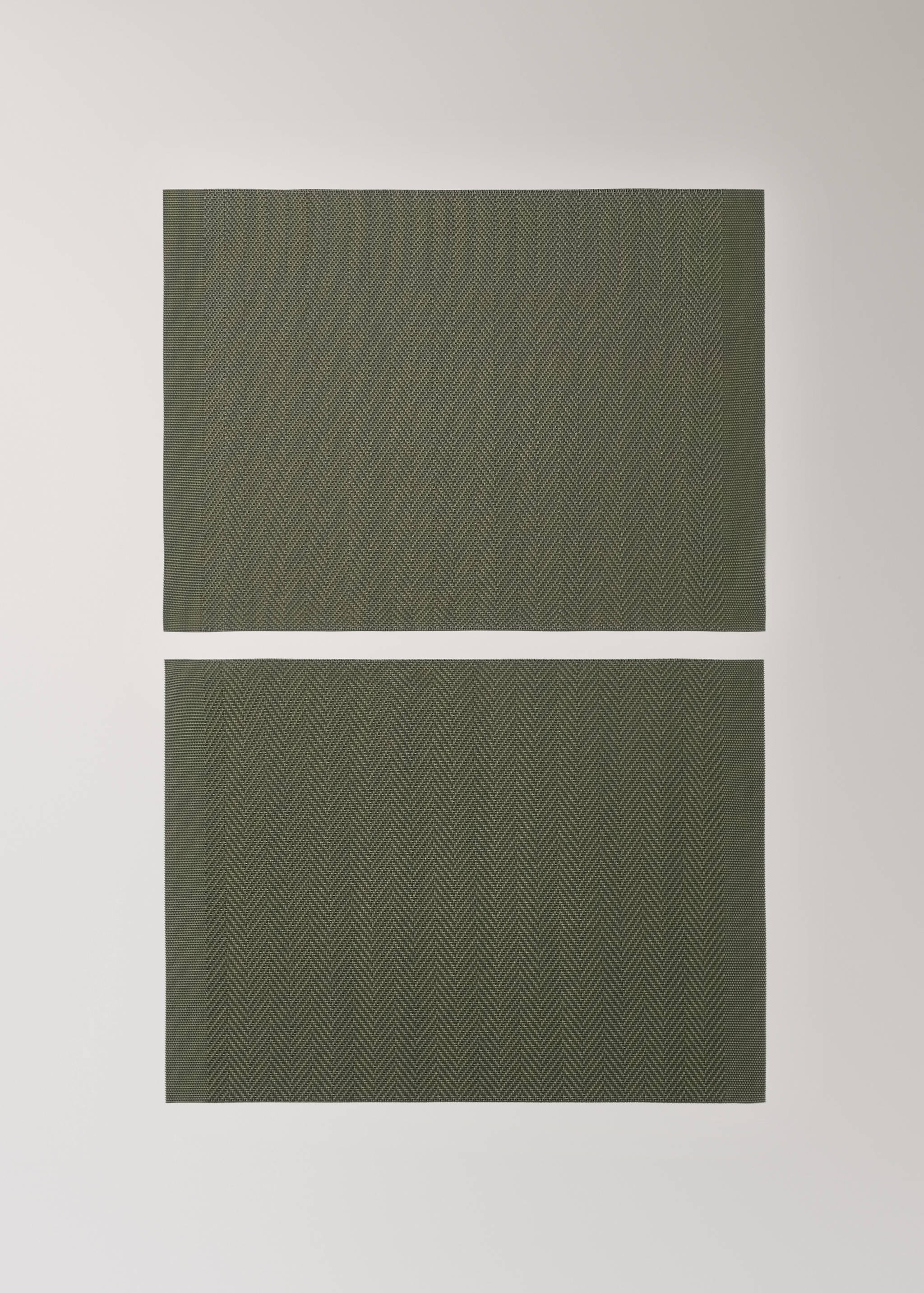 Two dark green woven herringbone placemats.