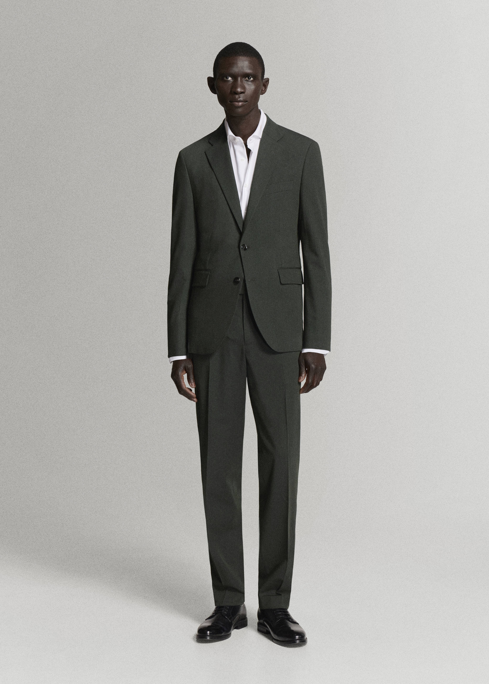 Dark green suit trousers with straight leg silhouette, worn with matching jacket and white shirt.