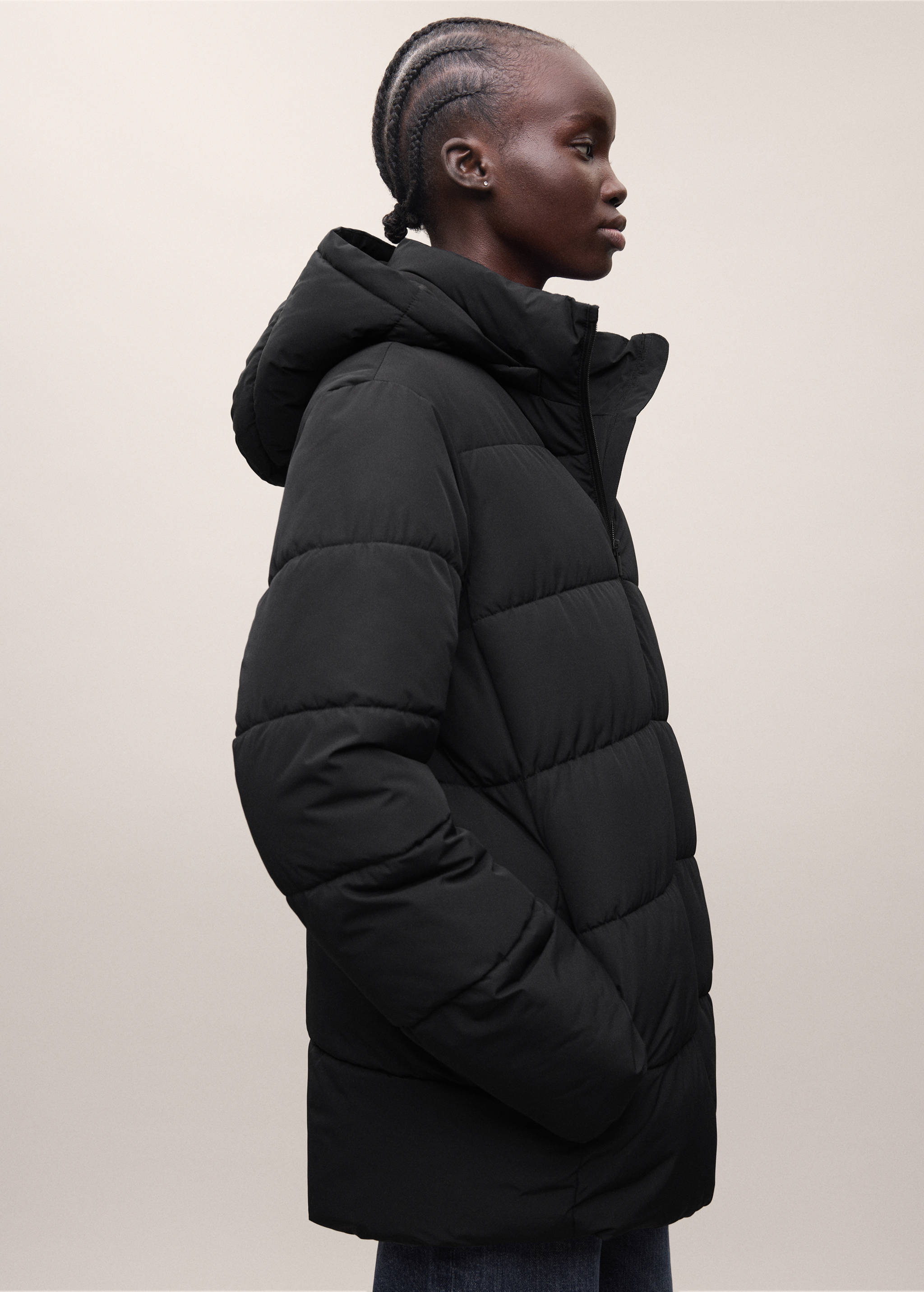 Black padded anorak with horizontal quilting, high collar, and hood.