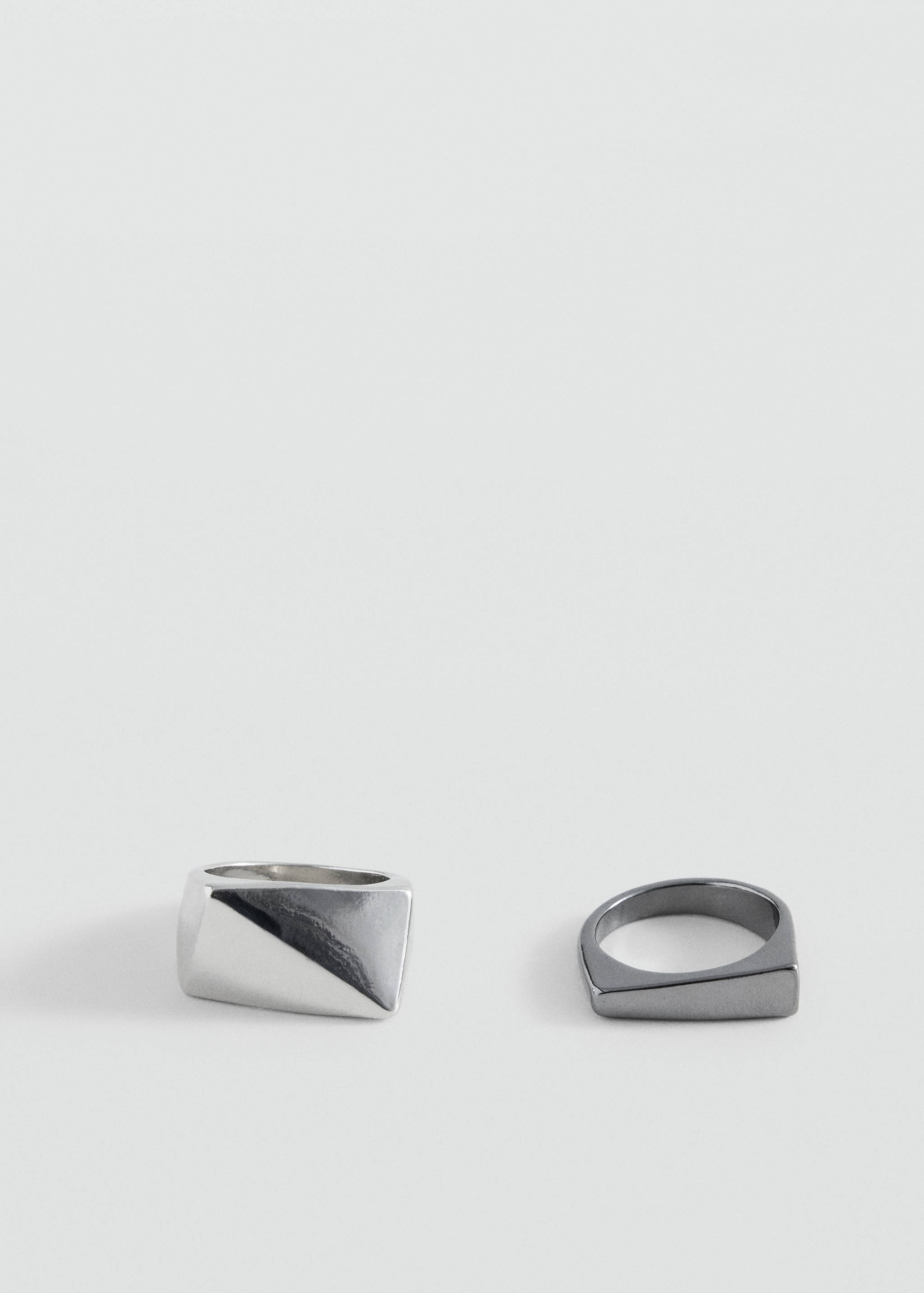 Set of two silver-tone metal rings with geometric faceted designs.