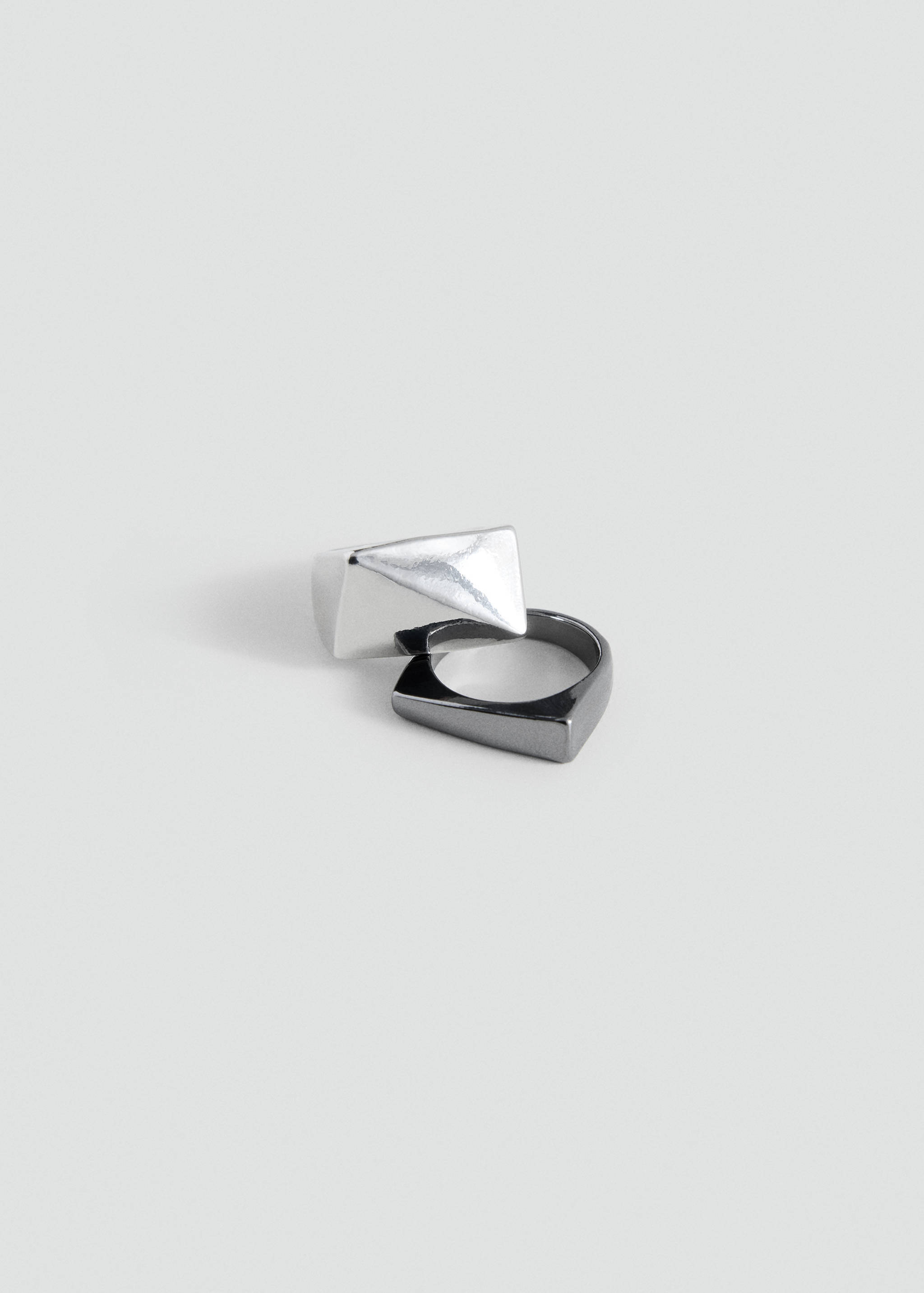 Interlocking silver-tone faceted pyramid ring and dark gunmetal ring.