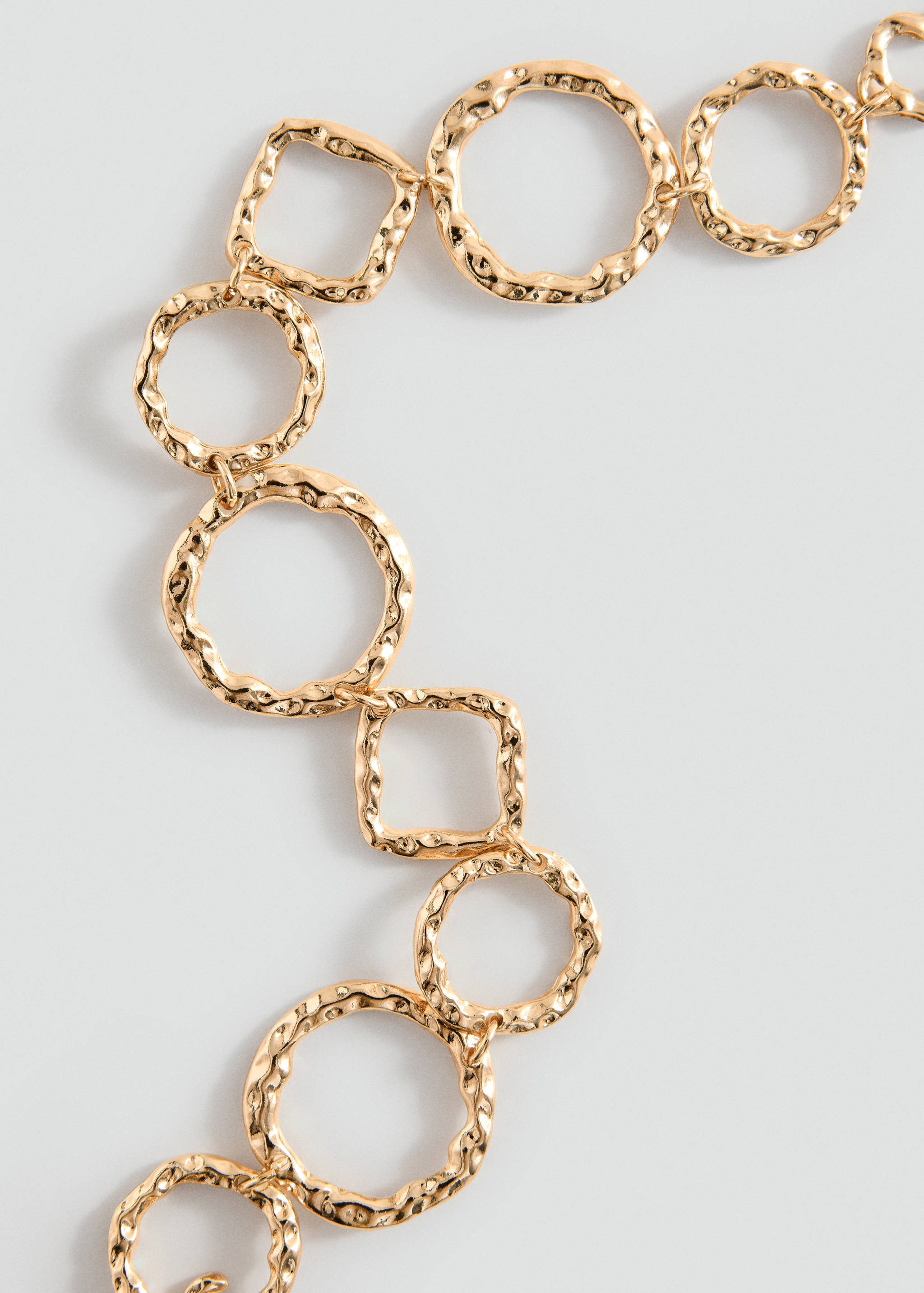 Gold-toned metal link bracelet with textured circular and square links.