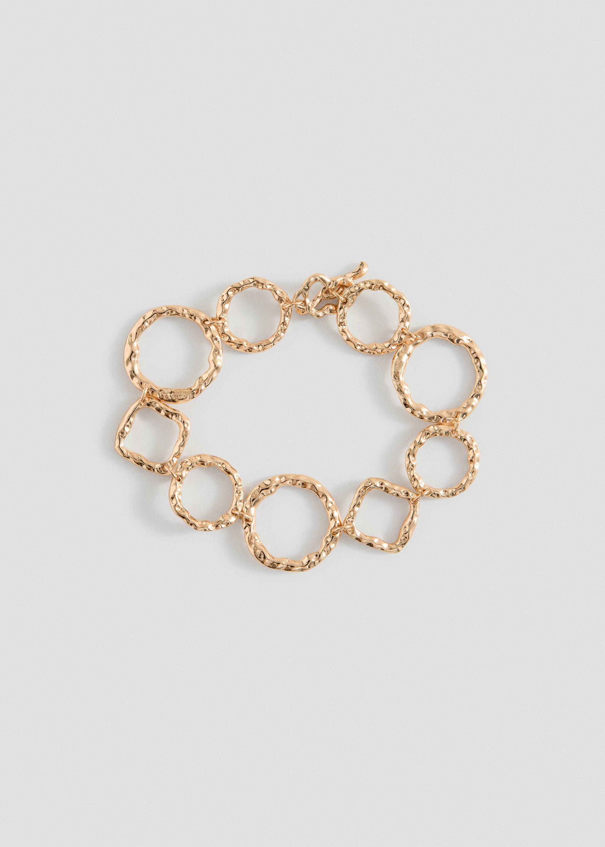 Gold-toned link bracelet with textured circular and square charms.