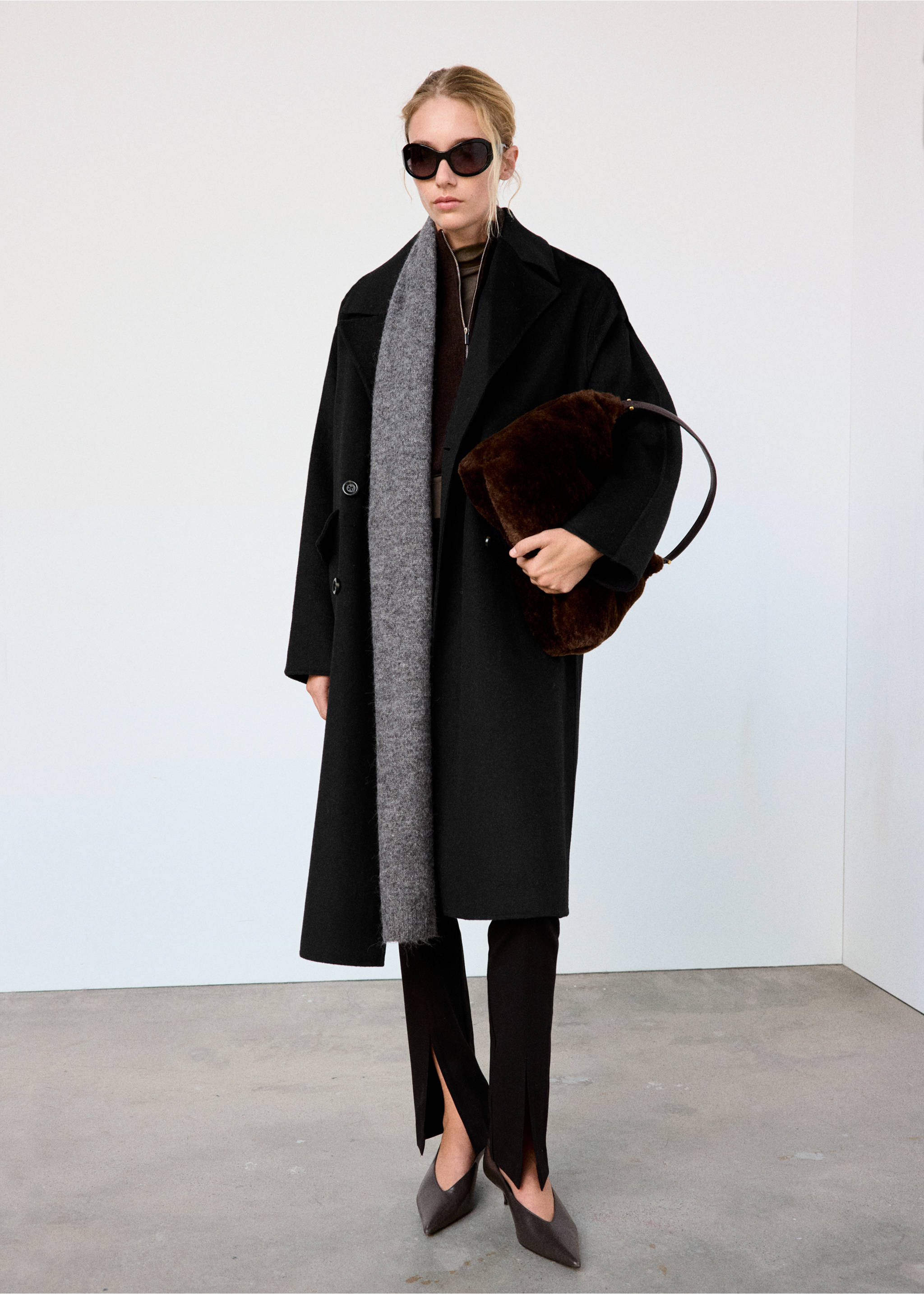 Black longline coat with lapels worn with a grey scarf and dark trousers with slits., Black. Ref: 37055845-02.