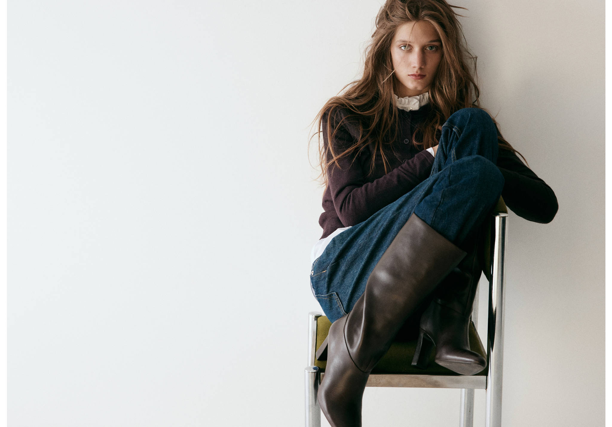 Dark brown heeled boots worn with jeans and a dark top.
