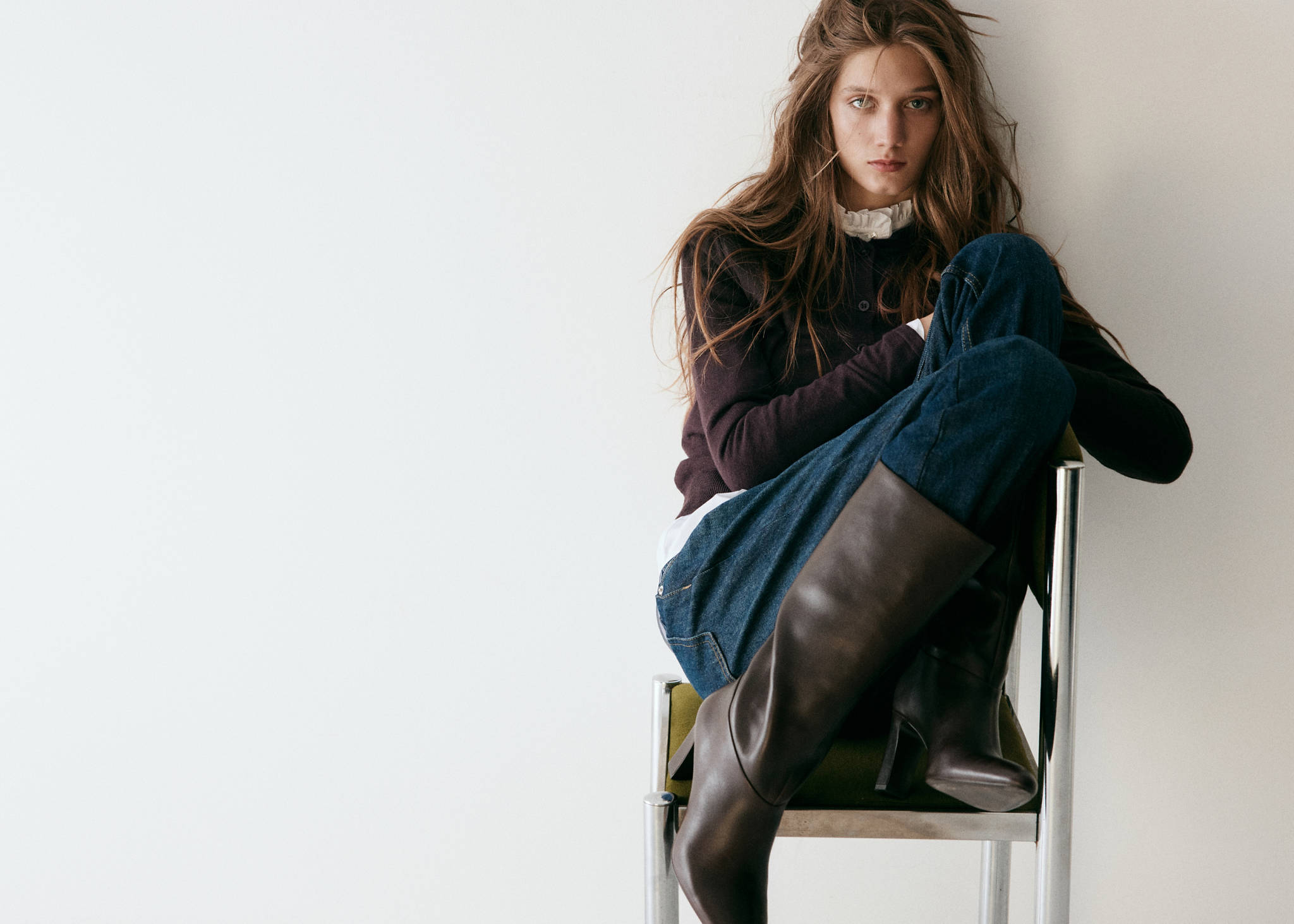 Dark brown heeled boots worn with jeans and a dark top.