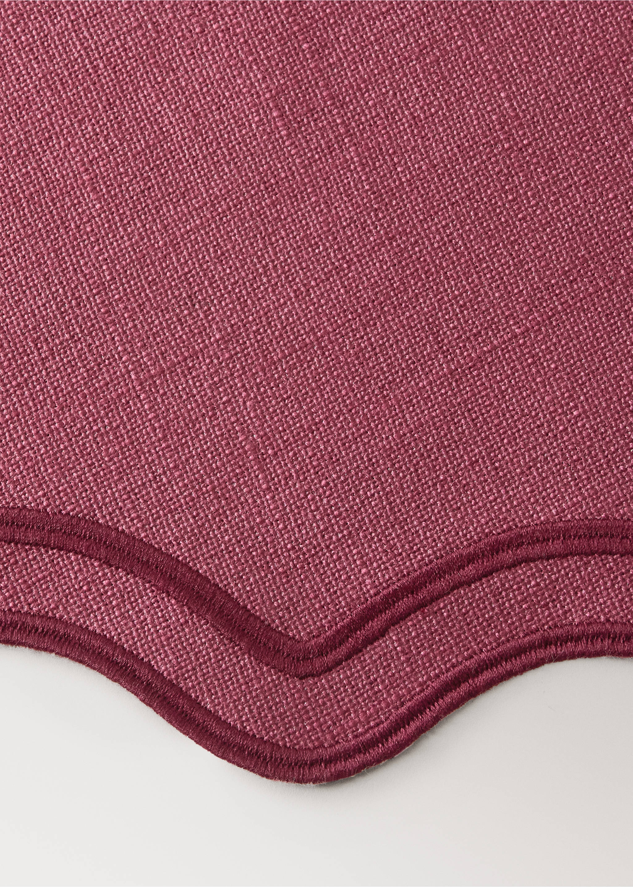 Raspberry pink table mat with a textured weave and scalloped embroidered edge., Red. Ref: 37056332-00.