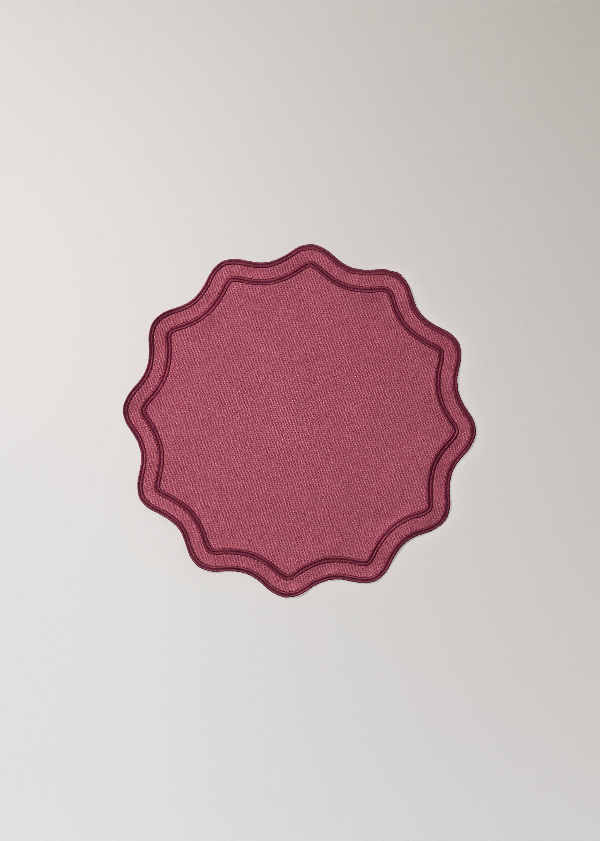 Round burgundy placemat with a scalloped edge and stitched border., Red. Ref: 37056332-00.