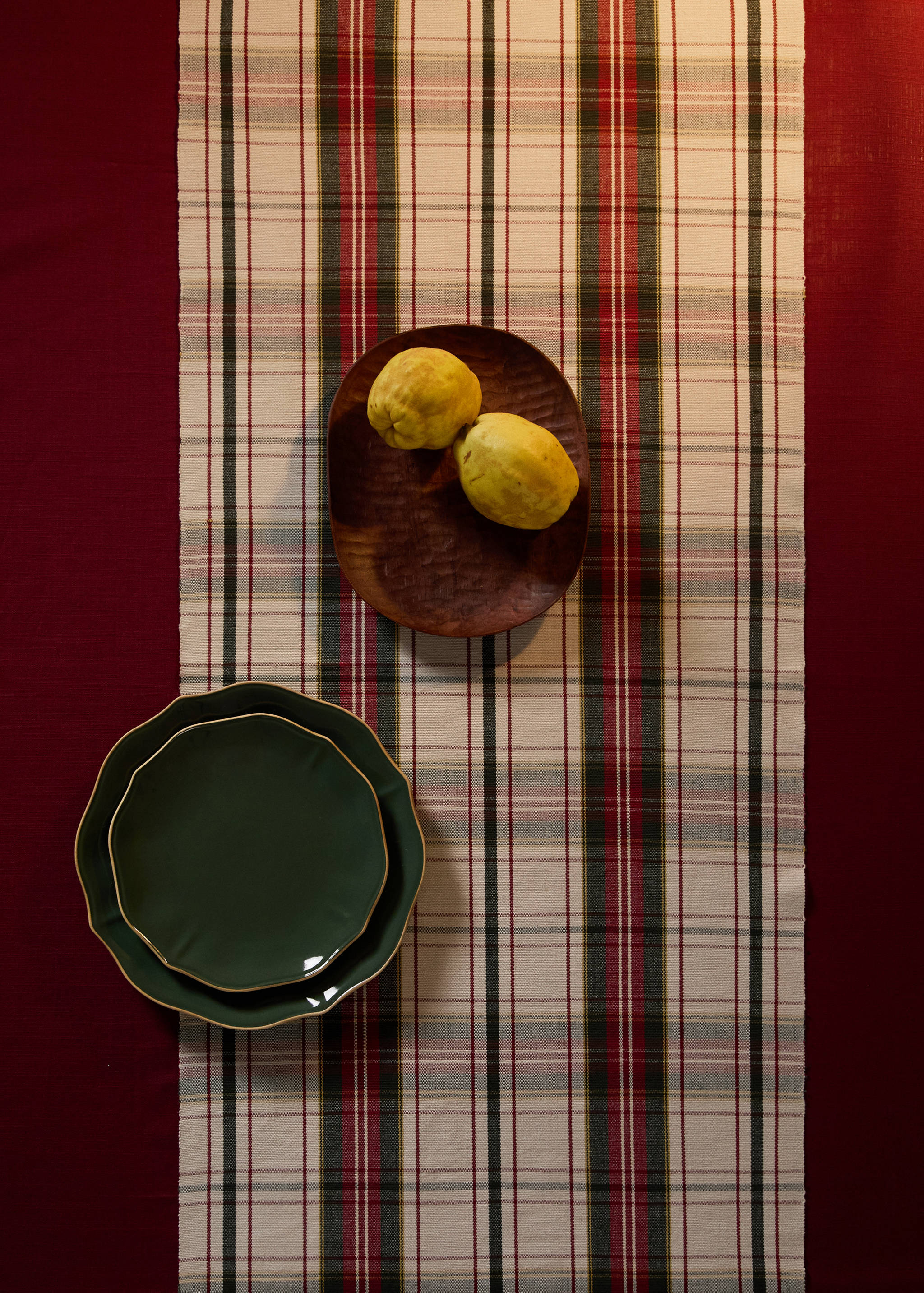 Plaid table runner in beige, red, dark green and black.