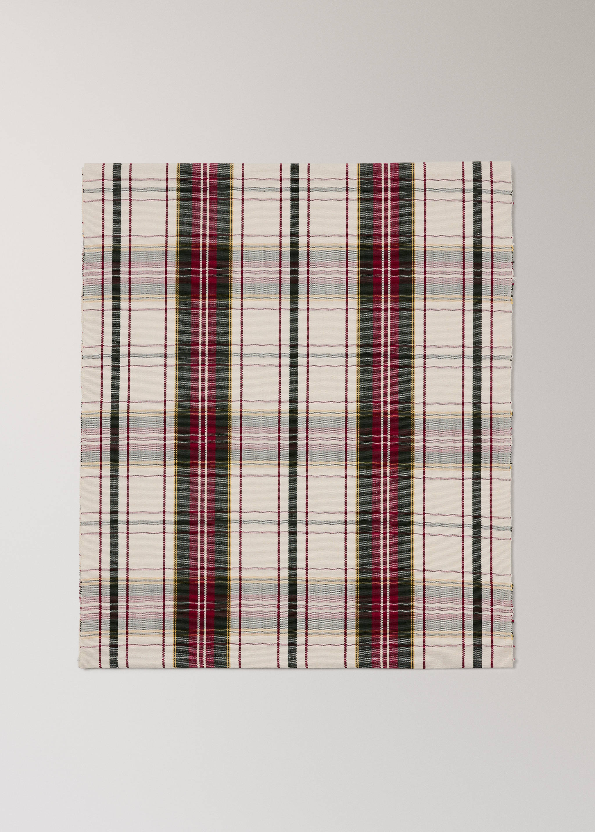 Off-white plaid table runner with red, dark green, and black stripes.