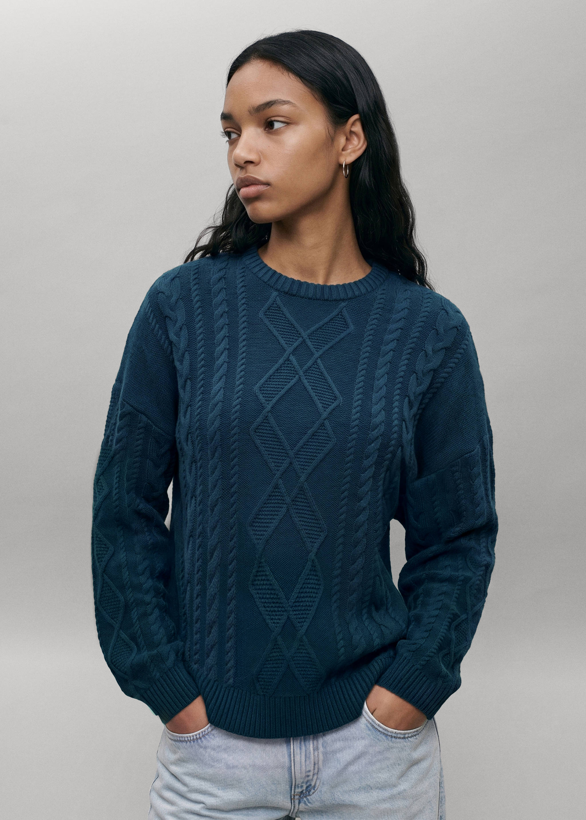 Teal cable-knit sweater with a ribbed crew neck and diamond pattern.