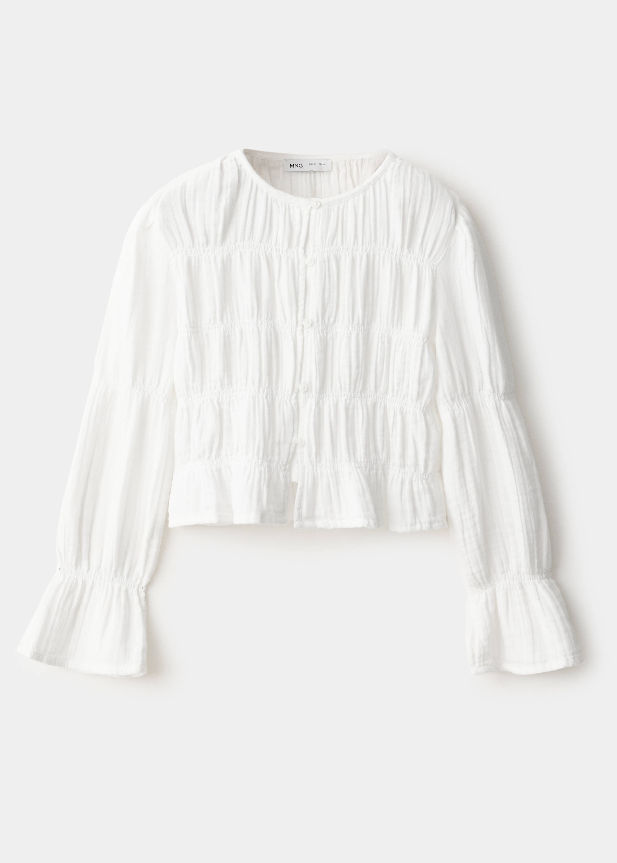 White long-sleeved smocked shirt with a rounded neckline and ruffled cuffs.