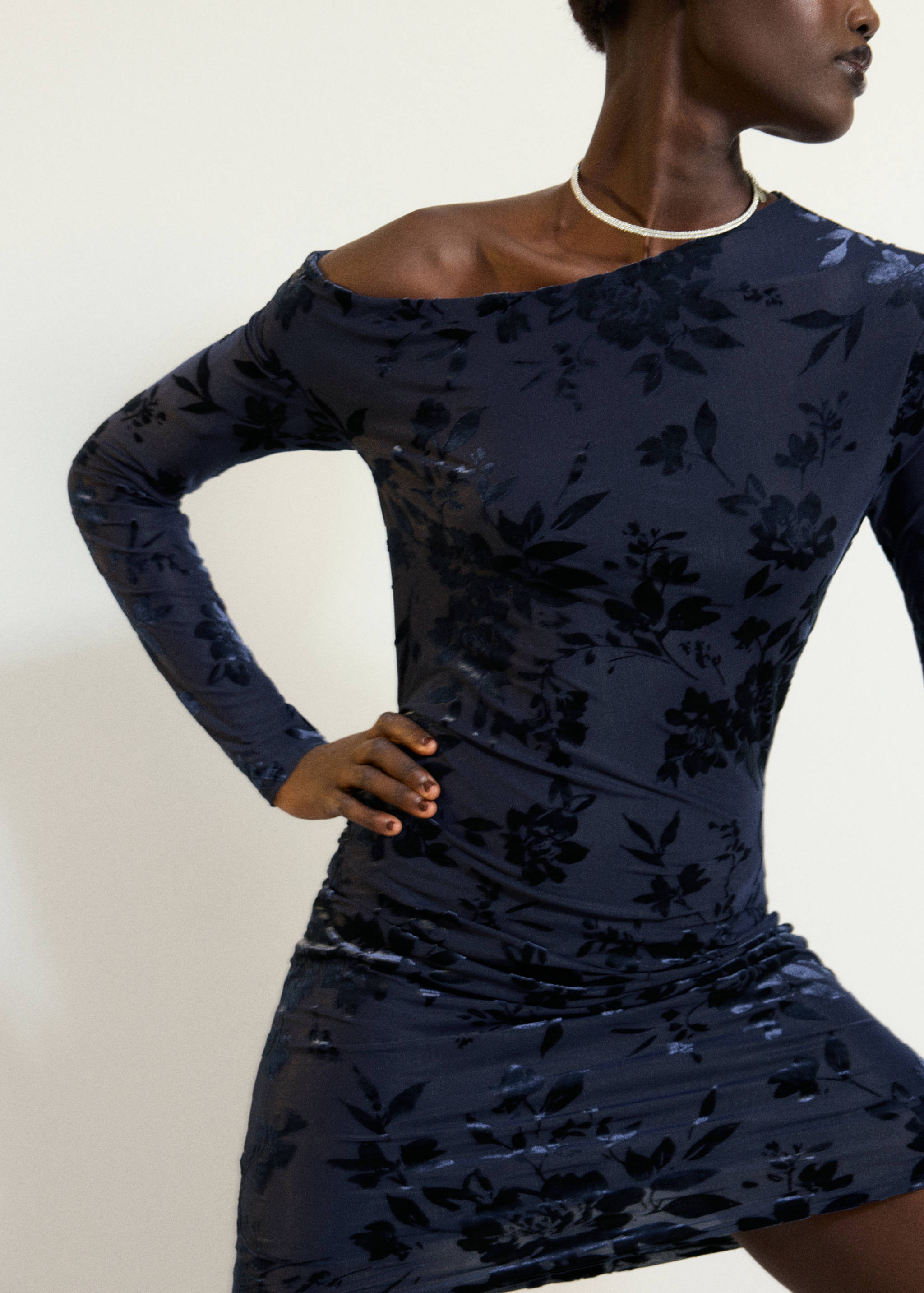 Navy blue long-sleeved dress with an off-the-shoulder neckline and floral velvet pattern.