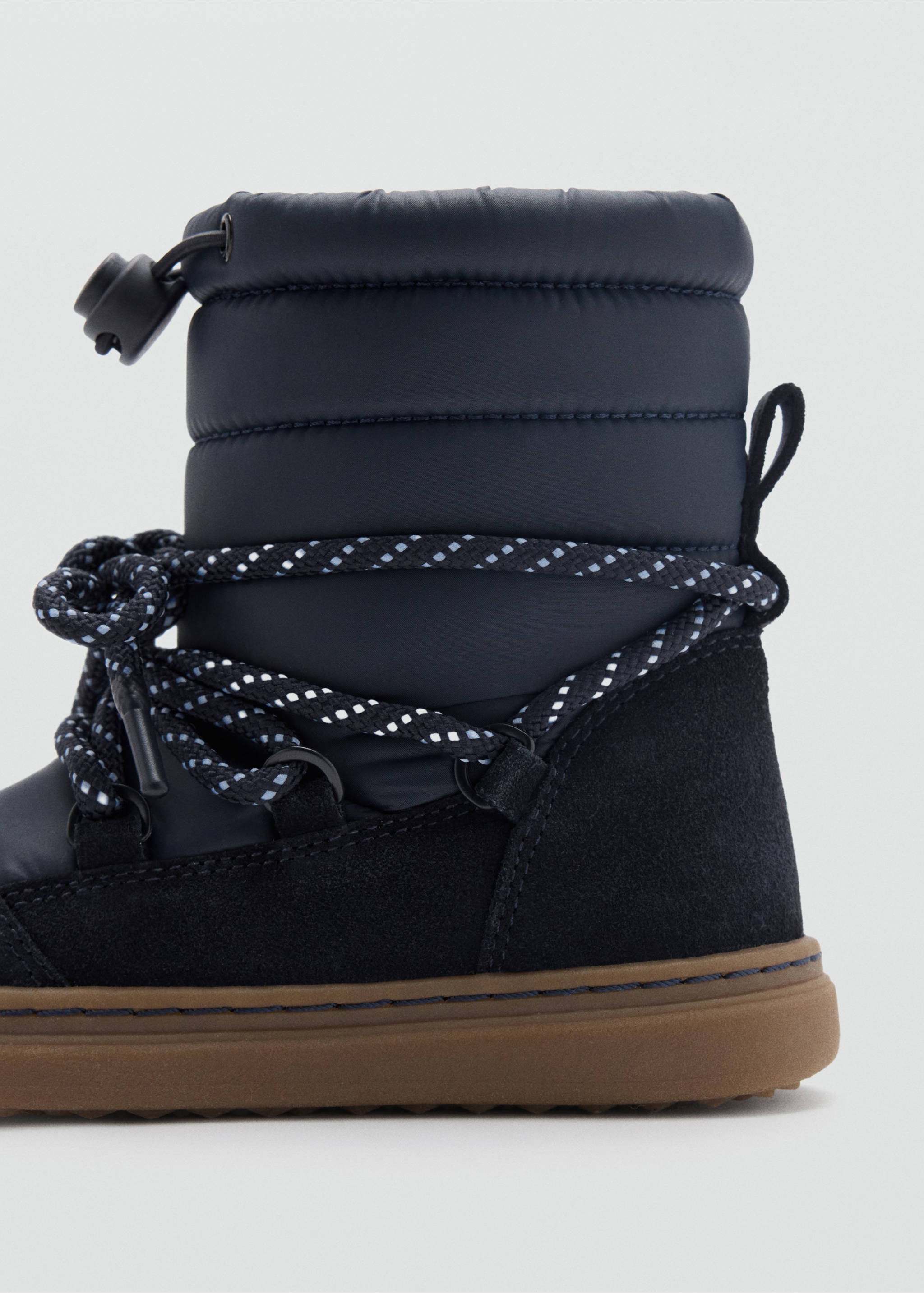 Close-up of a dark blue kids' boot with quilted shaft and patterned laces., Blue. Ref: 37057798-00.