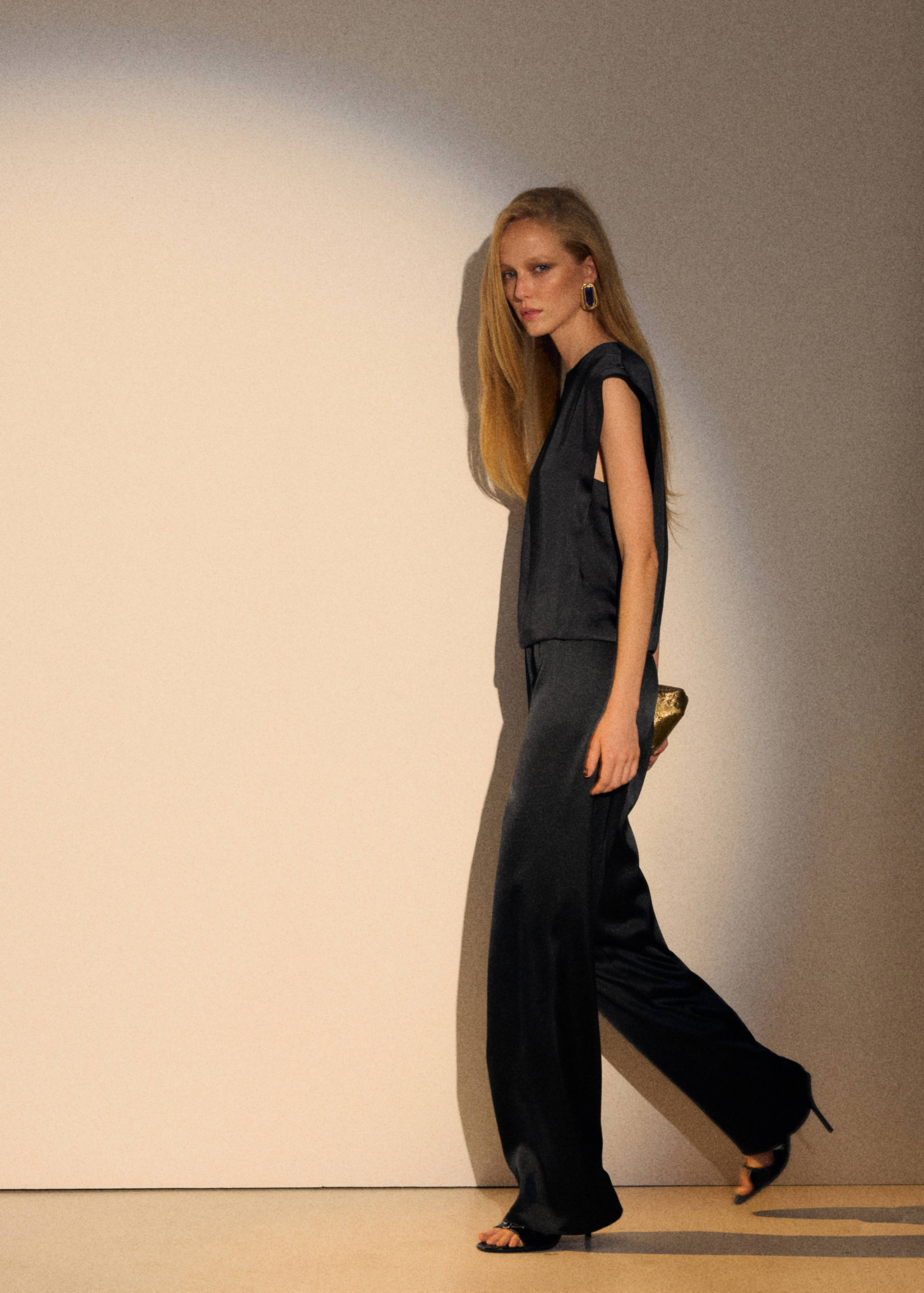 Dark satin wide-leg trousers worn with a matching sleeveless top.