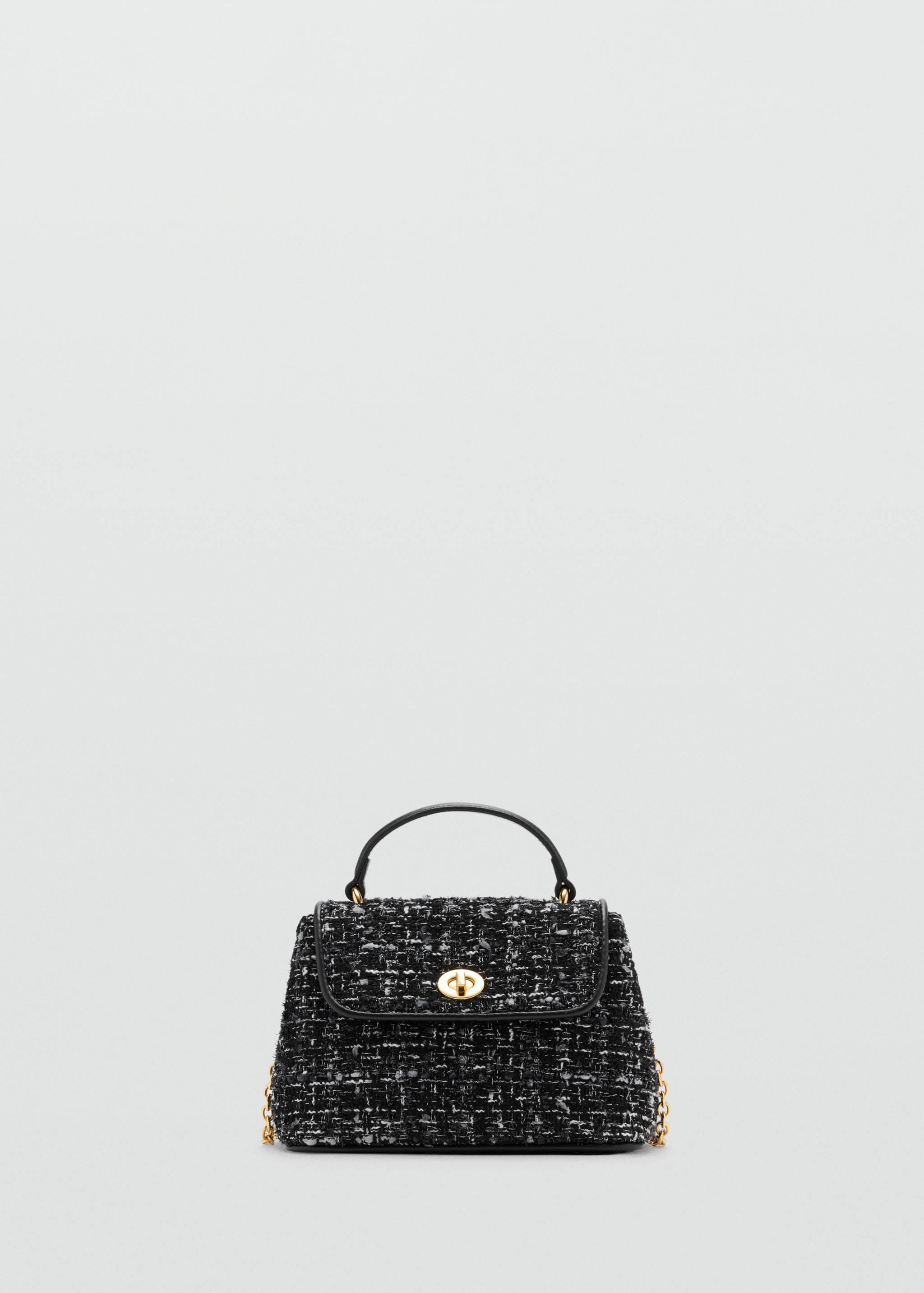 Bolso de mano de tweed en blanco y negro con cierre de giro dorado y asa superior.