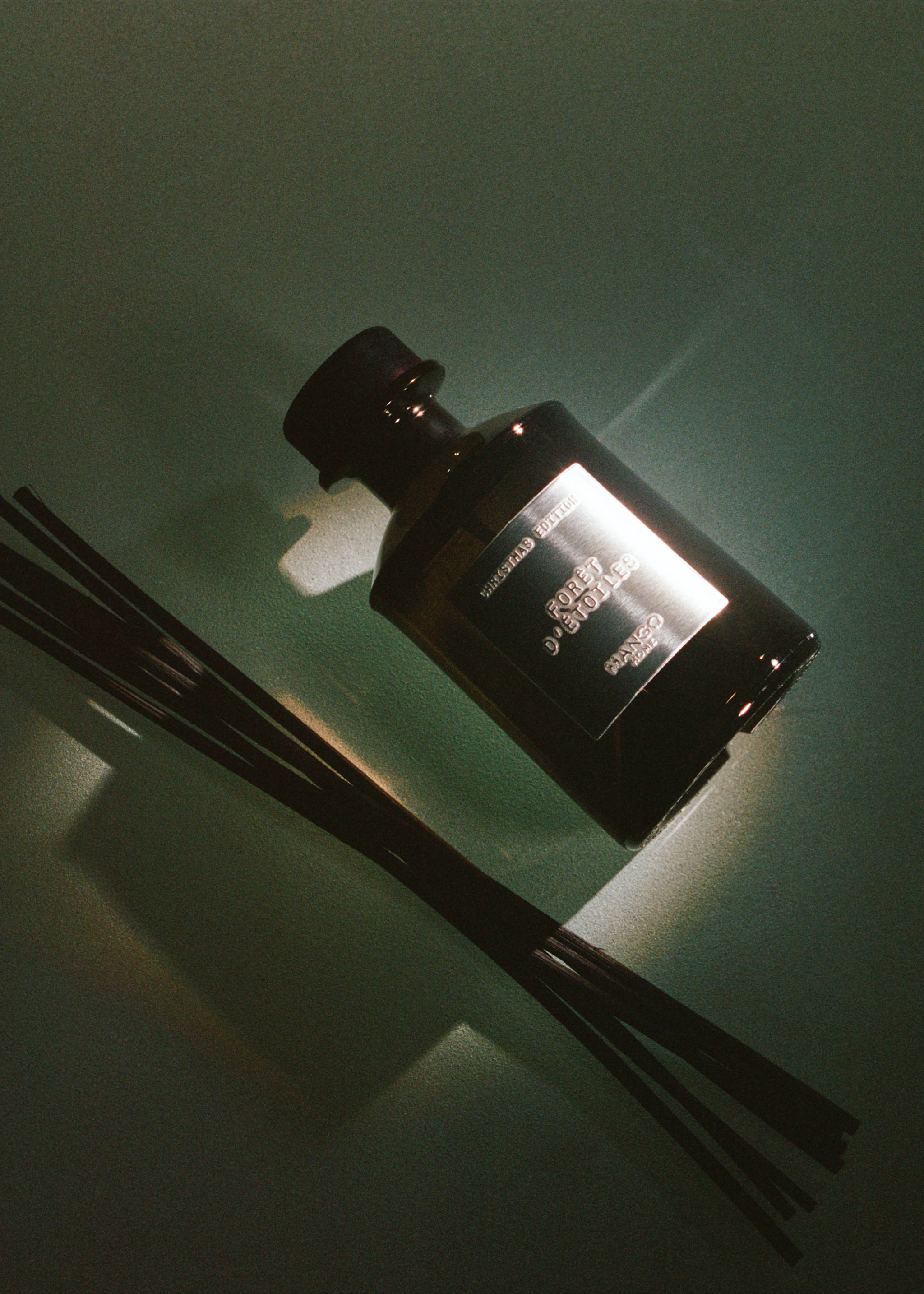 Dark glass reed diffuser bottle with metallic label and black reeds., Silver. Ref: 37057814-00.