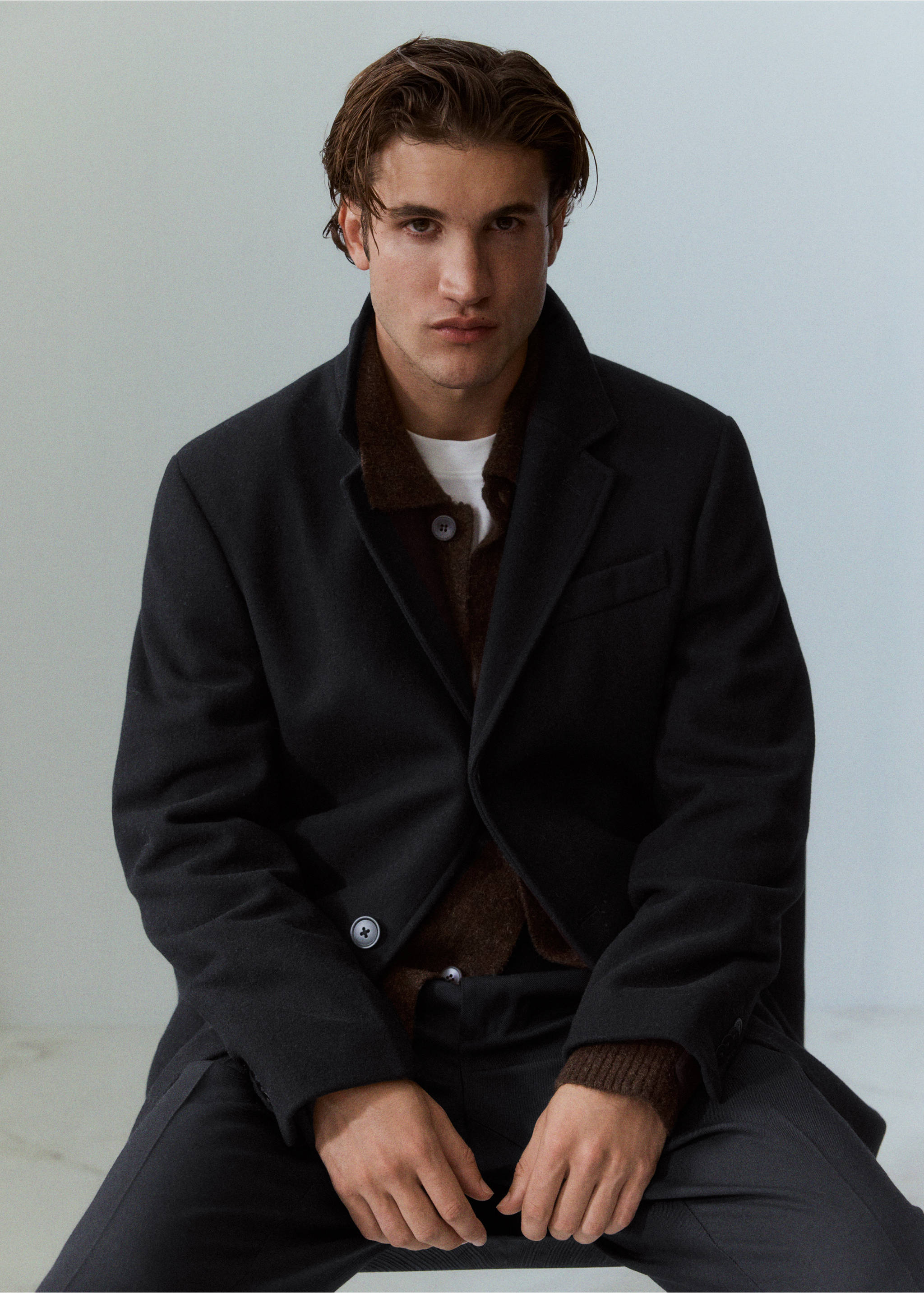 Dark grey coat with lapel collar worn over a brown knitted polo shirt., Black. Ref: 37057883-00.