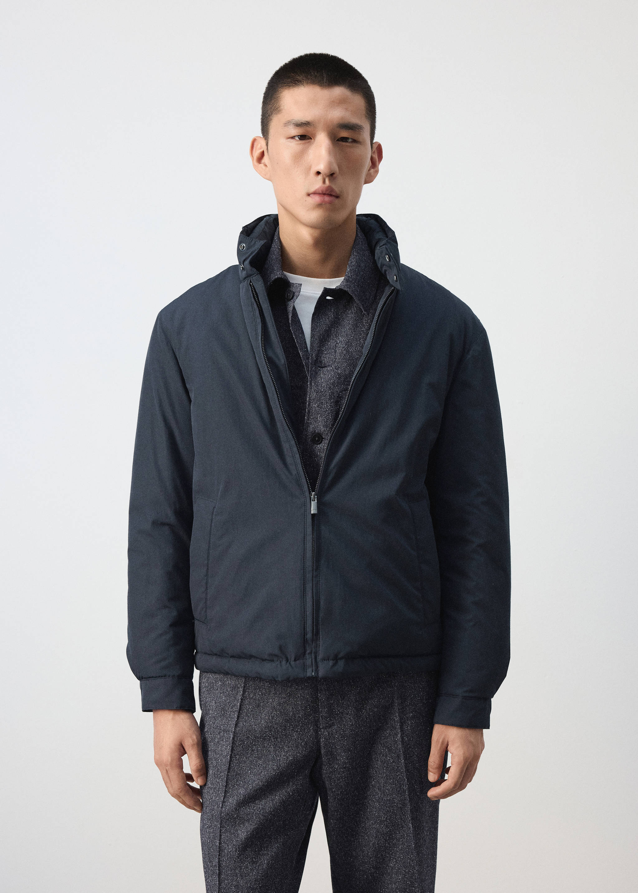 Navy blue zip-up jacket with a high collar and long sleeves worn by a model.