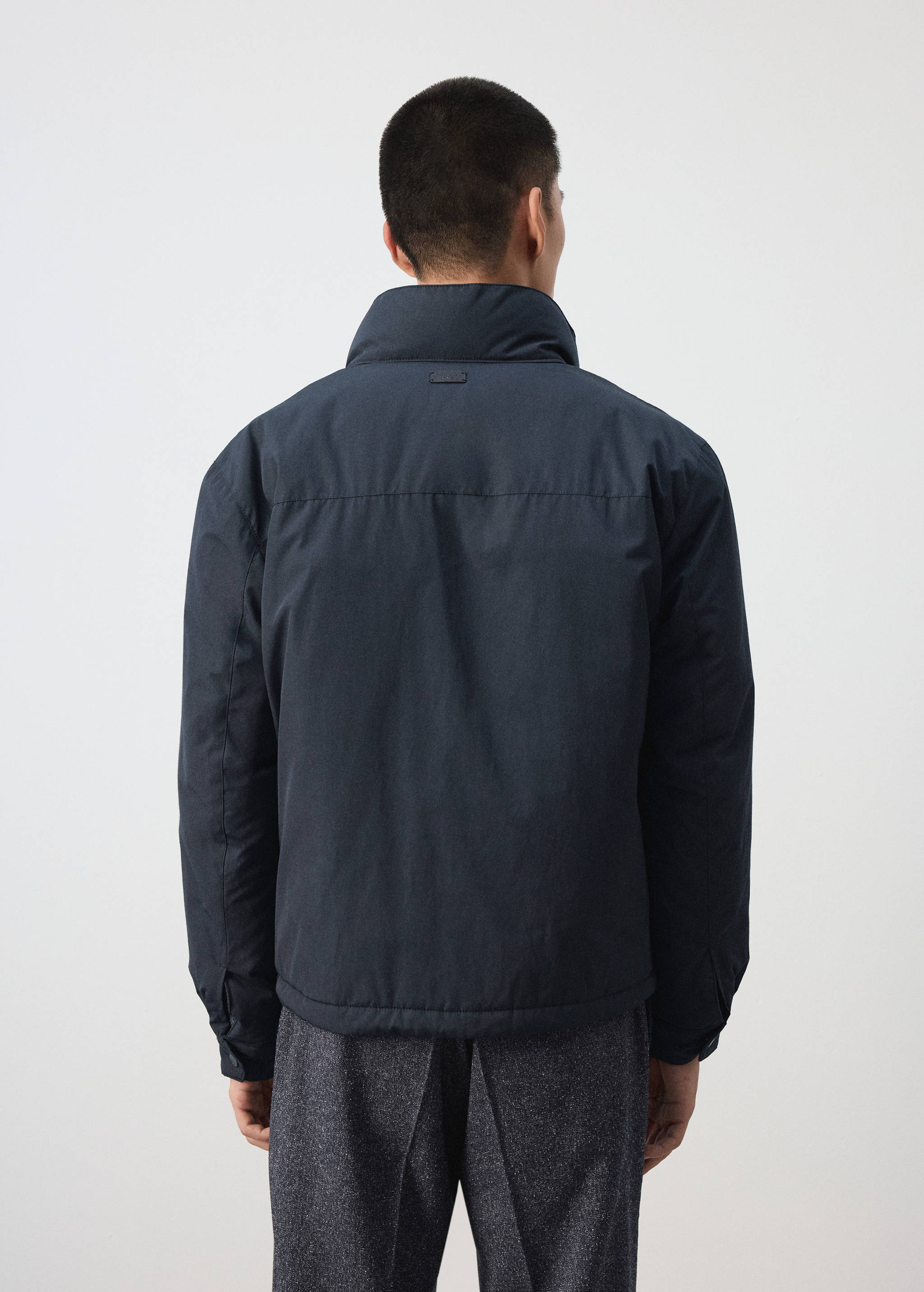 Dark navy blue jacket with a high collar, shown from the back.
