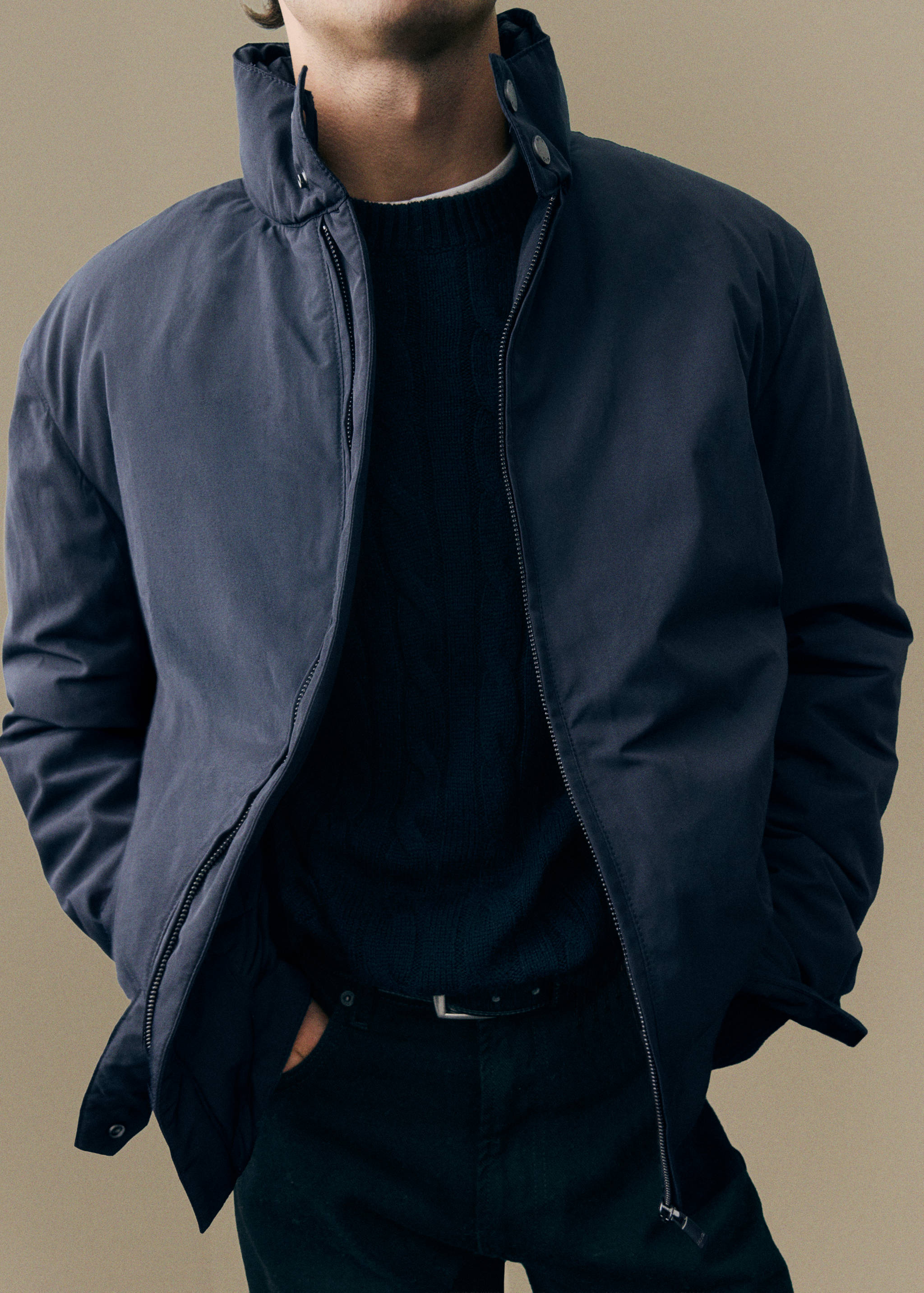 Navy blue jacket with a high collar and front zip.