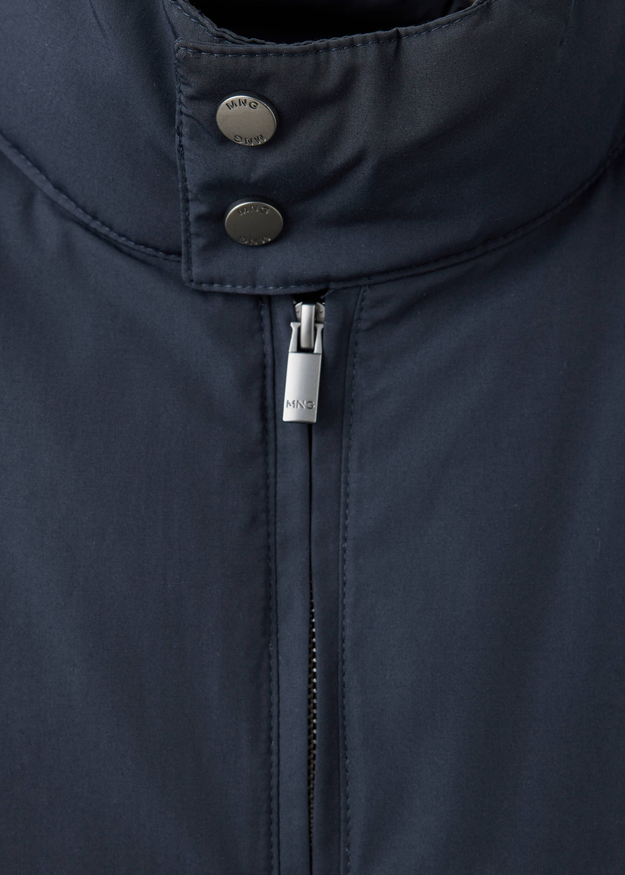 Navy jacket detail showing the collar with snap buttons and zipped front.