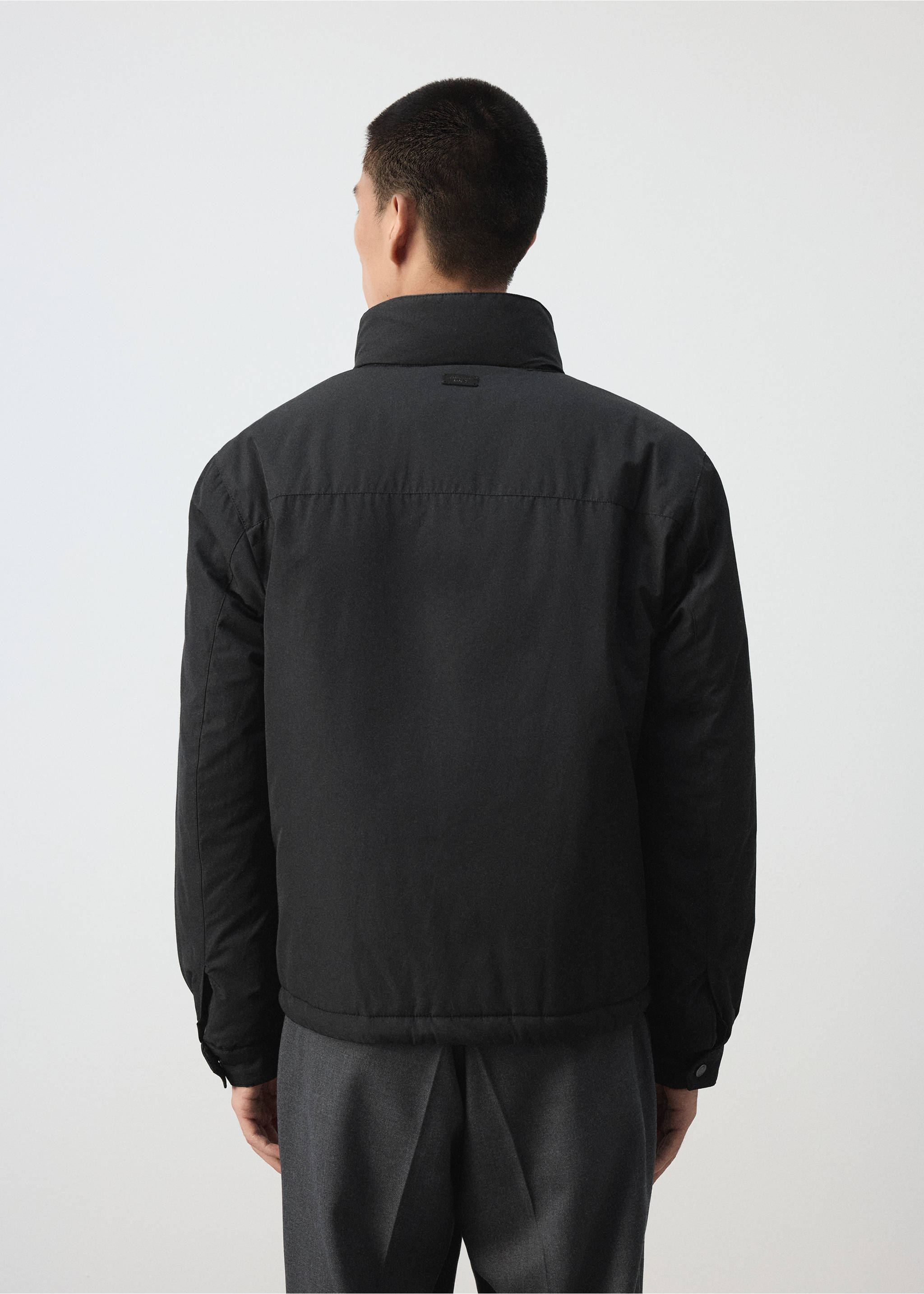 Vista trasera de una chaqueta negra con cuello alto, lucida por un modelo masculino., Negro. Ref: 37057884-00.