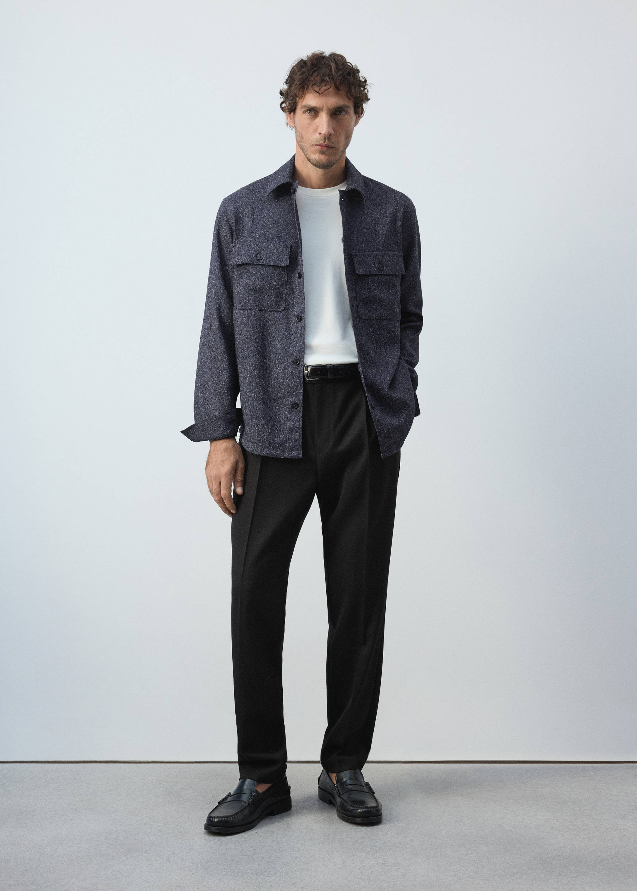 Navy blue melange overshirt with chest pockets, worn over a white t-shirt with black trousers.