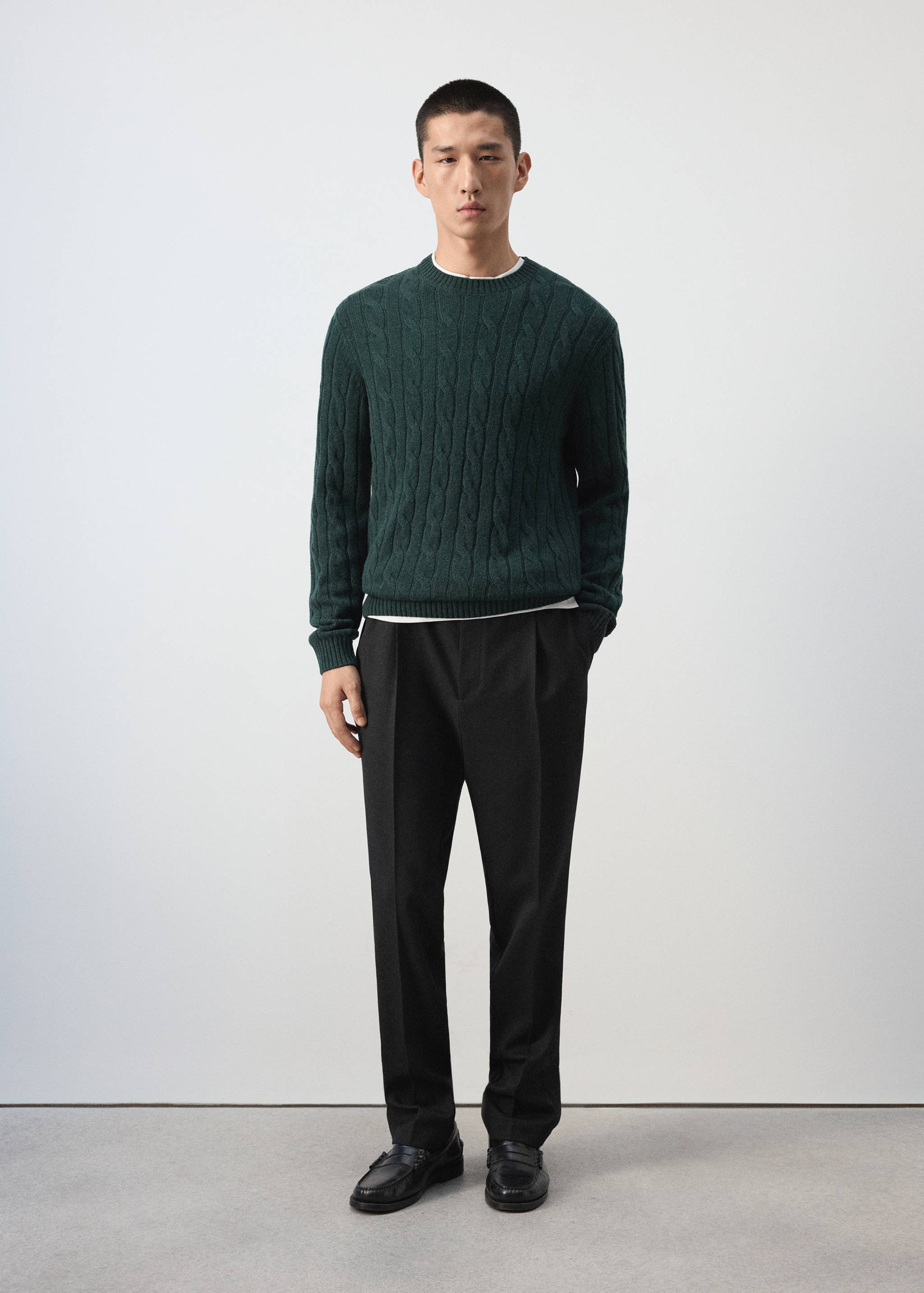 Dark green cable-knit jumper with a crew neck.