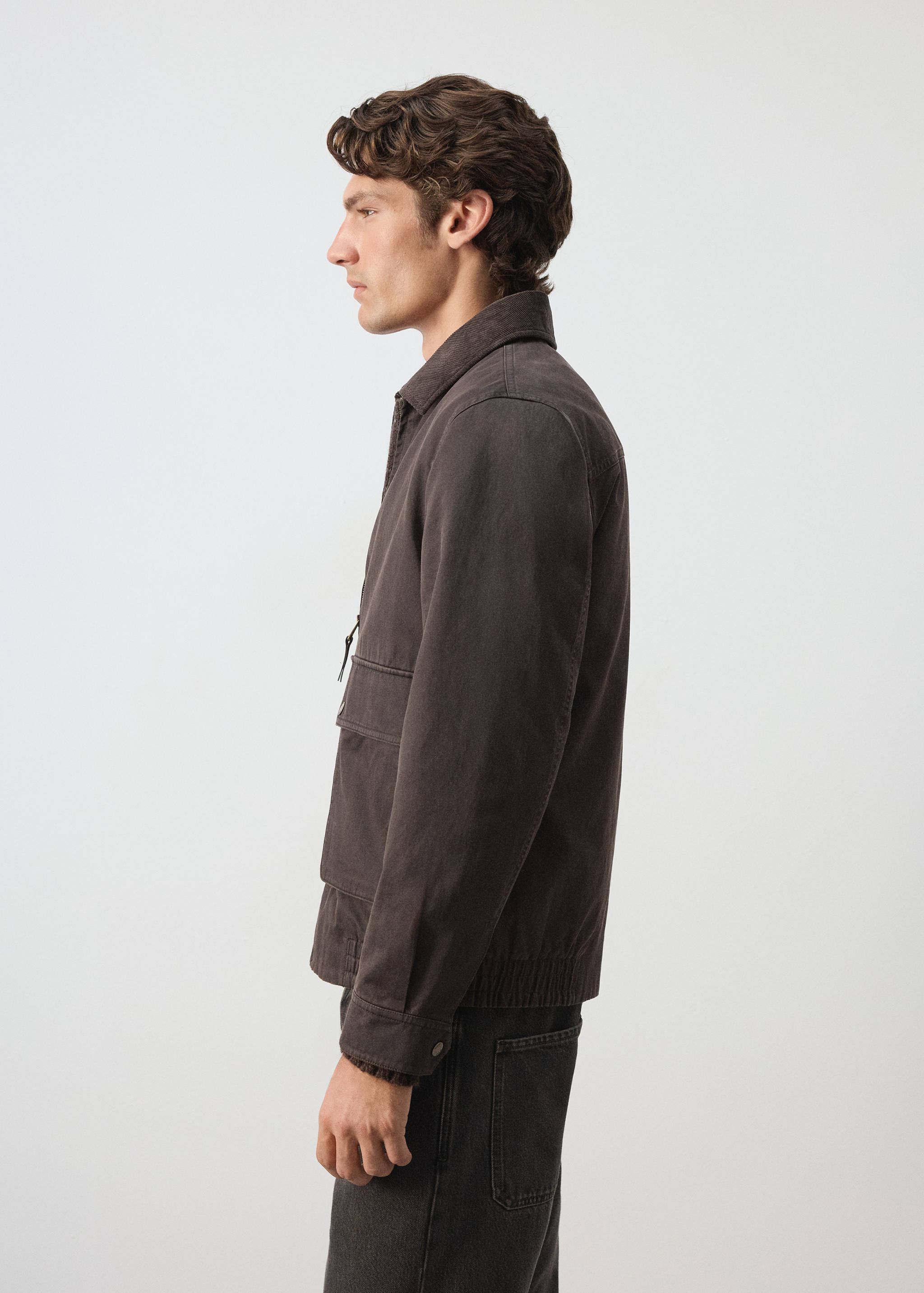 Dark brown cotton jacket with a collar, zip and flap pockets.