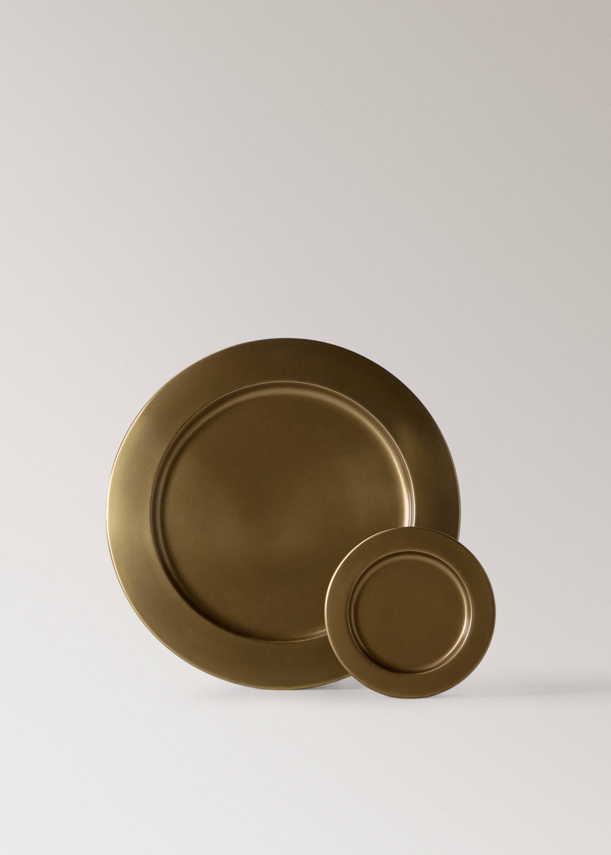 Close-up of two round bronze-coloured plates in different sizes.