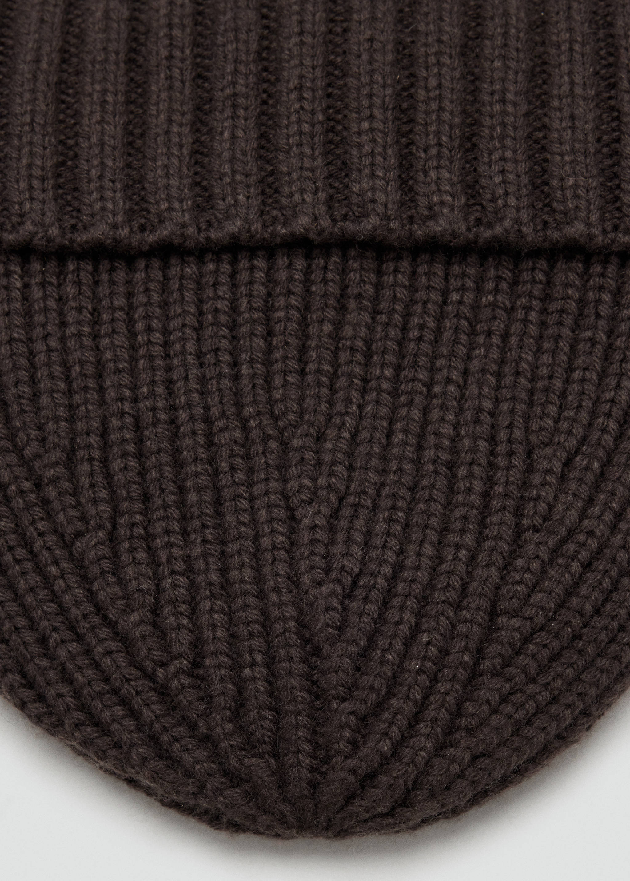 Close-up of a dark brown ribbed knit beanie.
