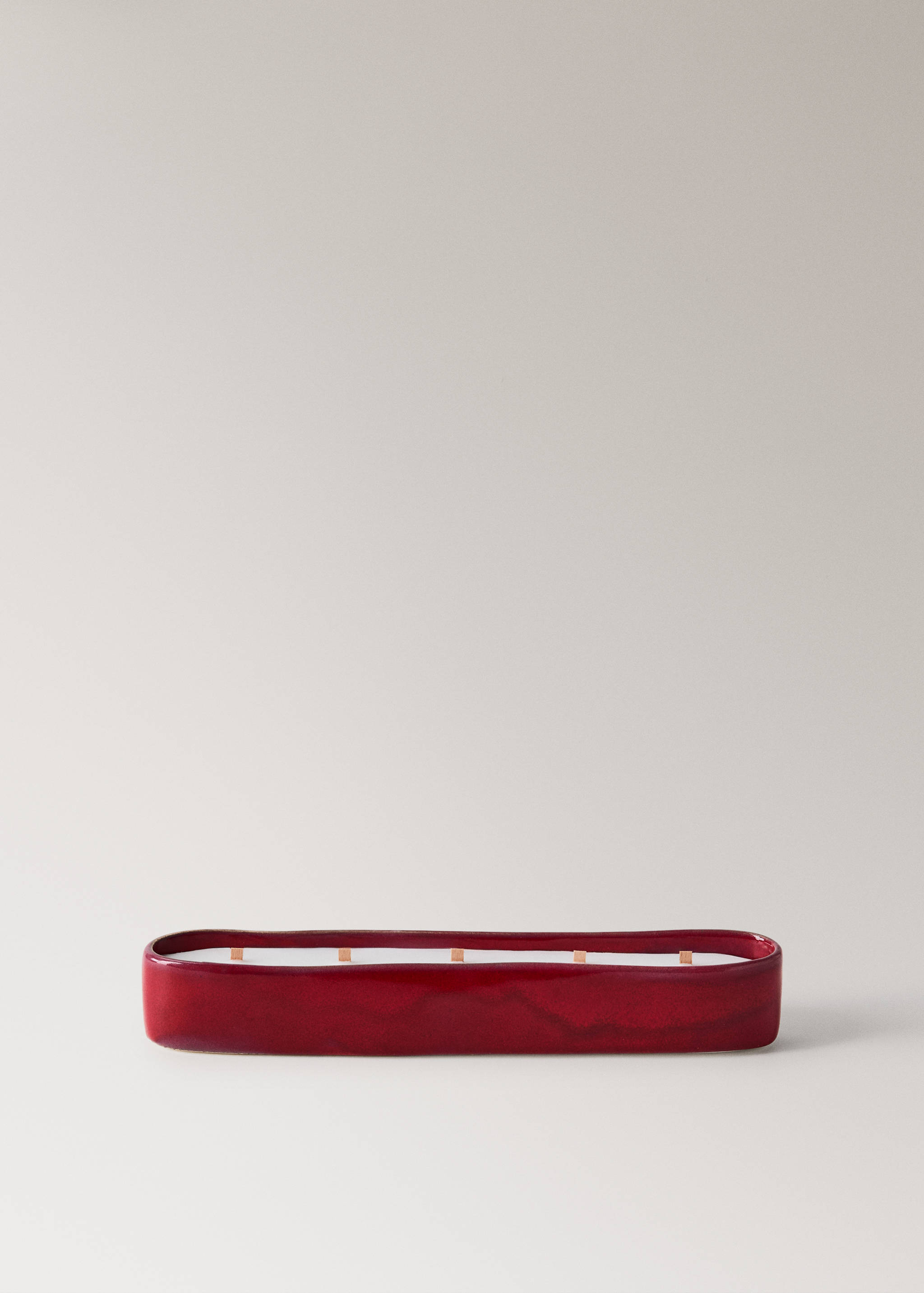 Elongated red ceramic candle with multiple wicks.