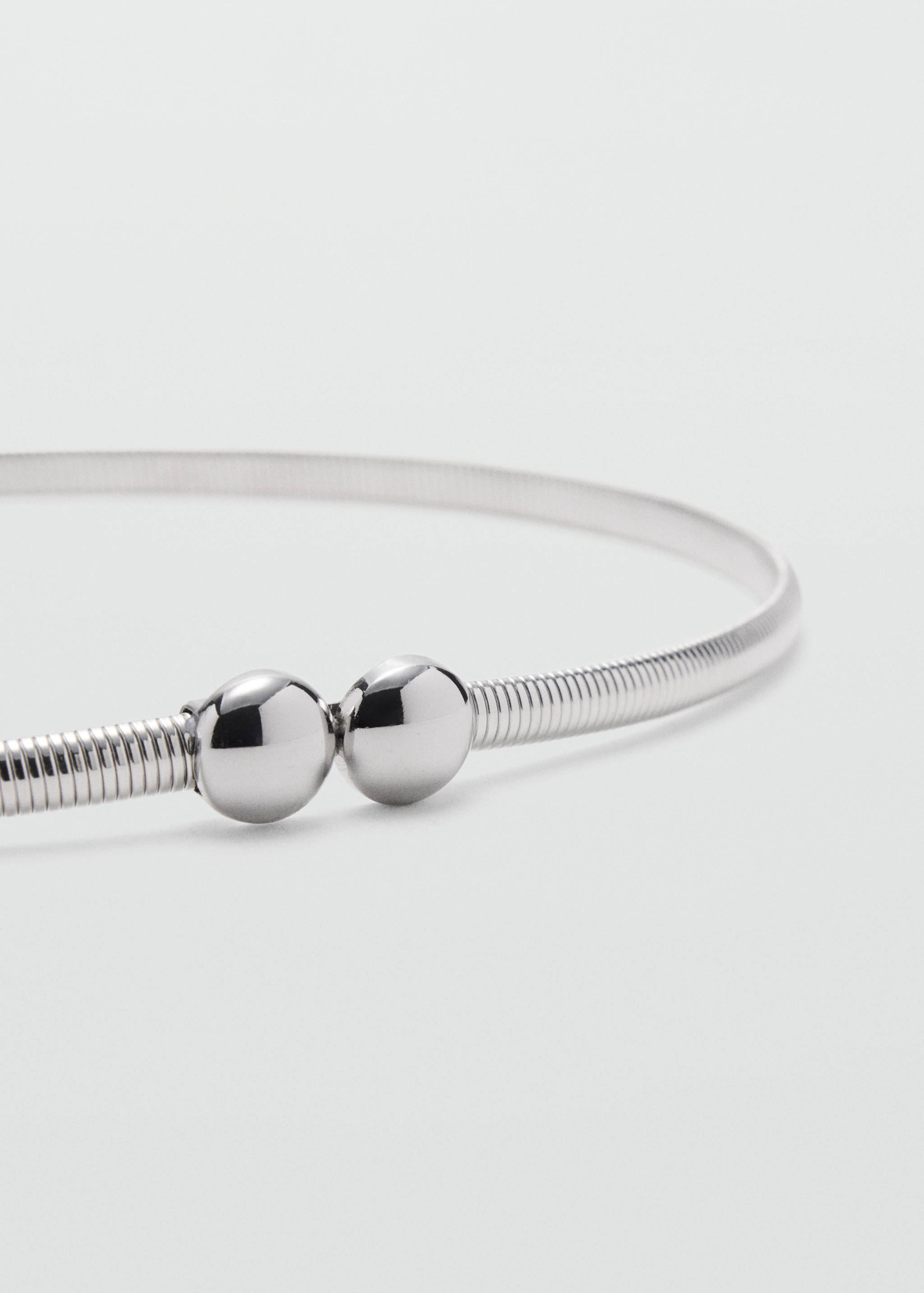 Silver metallic coiled belt with two polished spherical beads.