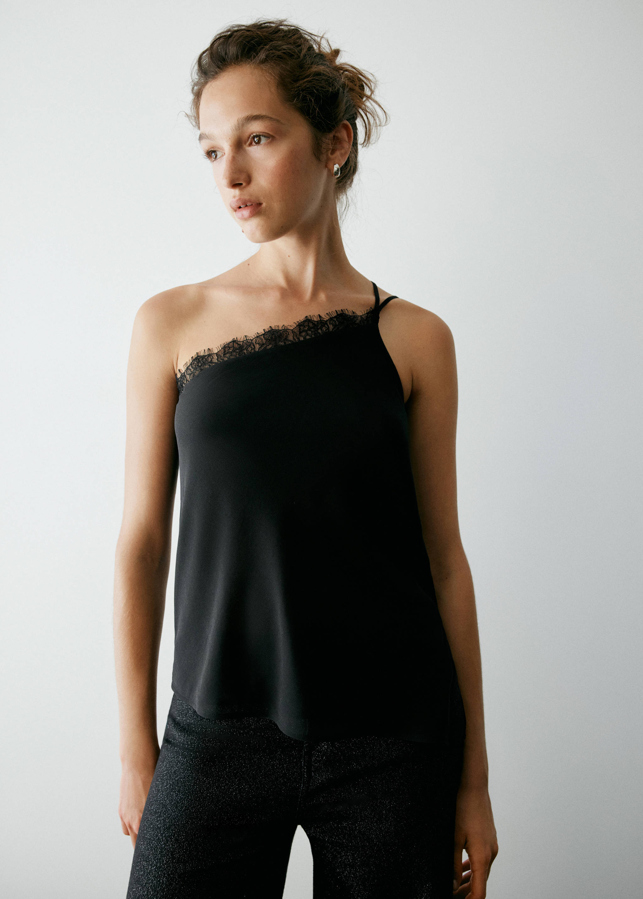 Black asymmetric top with lace trim and a single thin shoulder strap.