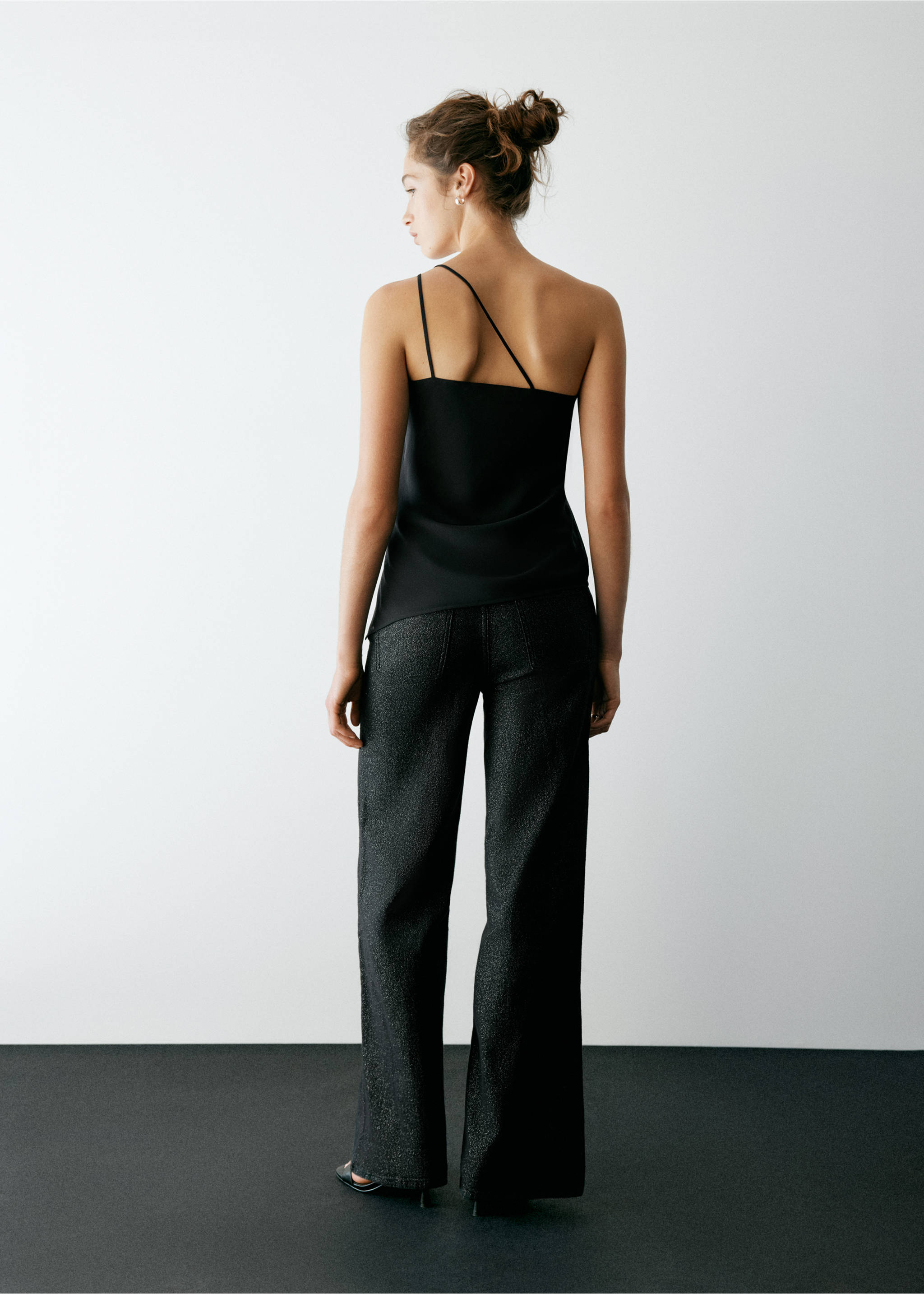 Black asymmetrical strap top from the back, paired with dark trousers., Black. Ref: 37057910-00.
