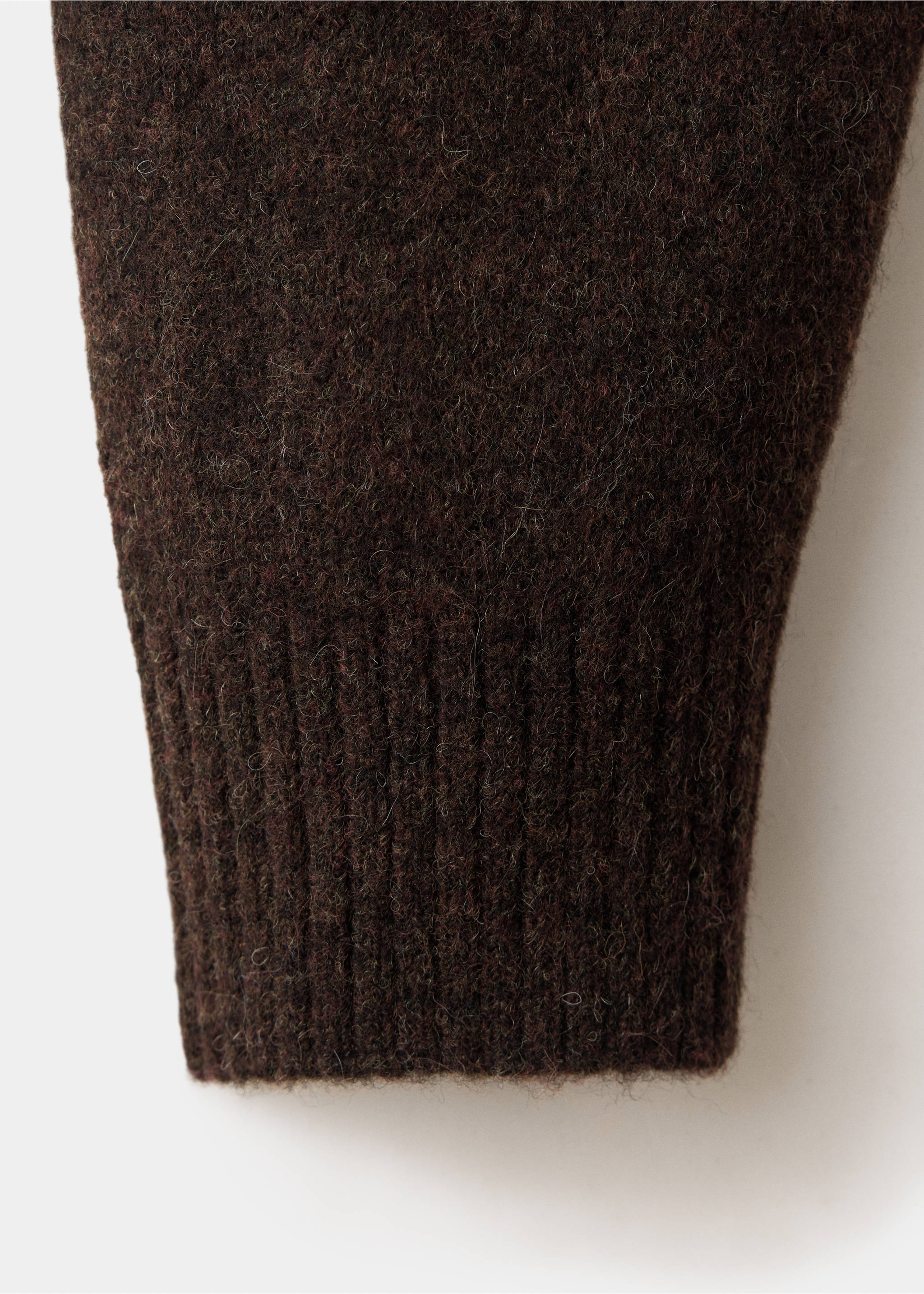 Close-up of the dark brown textured woolen knit fabric and ribbed cuff., Chocolate. Ref: 37057916-00.