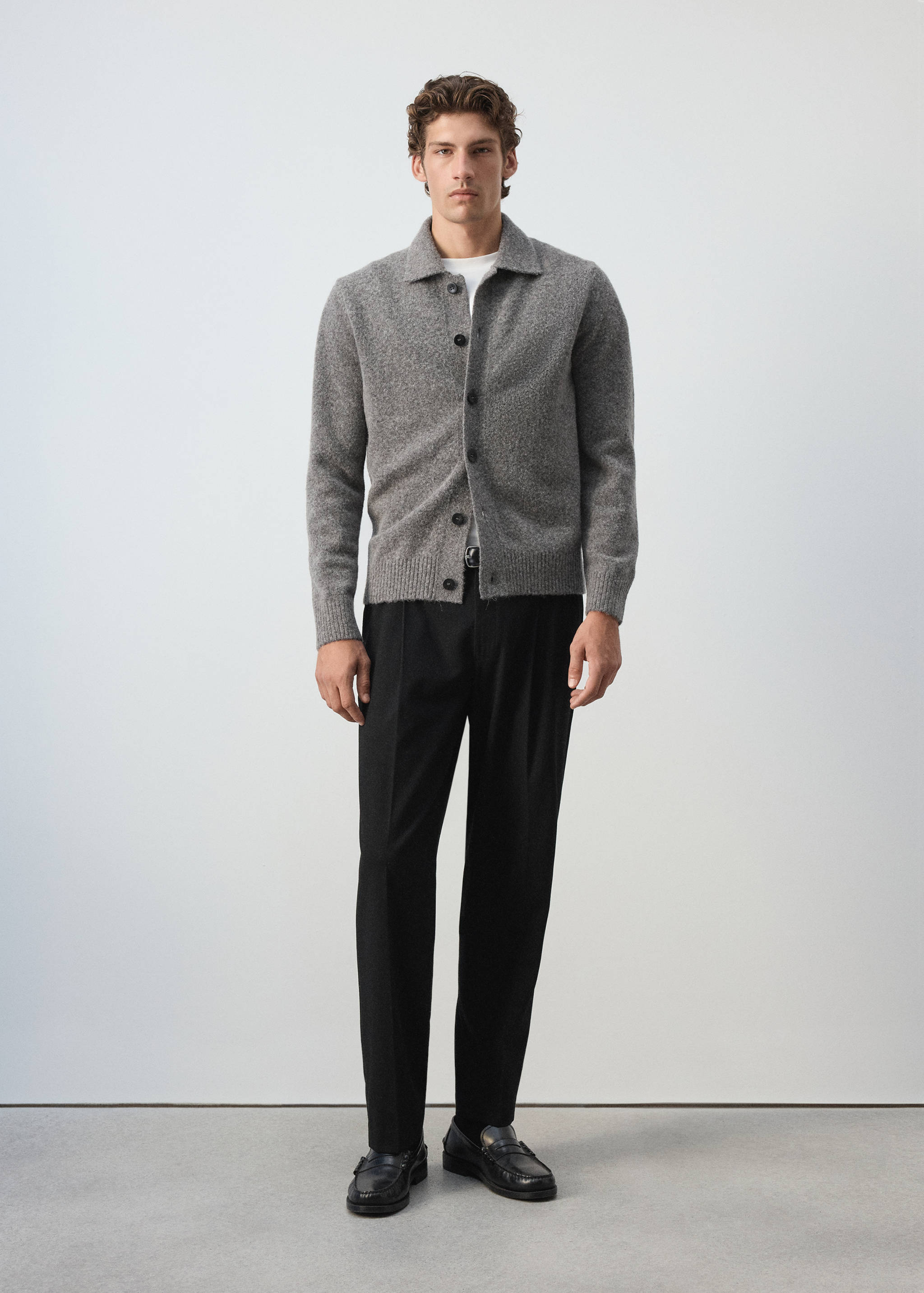 Grey button-up shirt worn over a white t-shirt with black trousers.