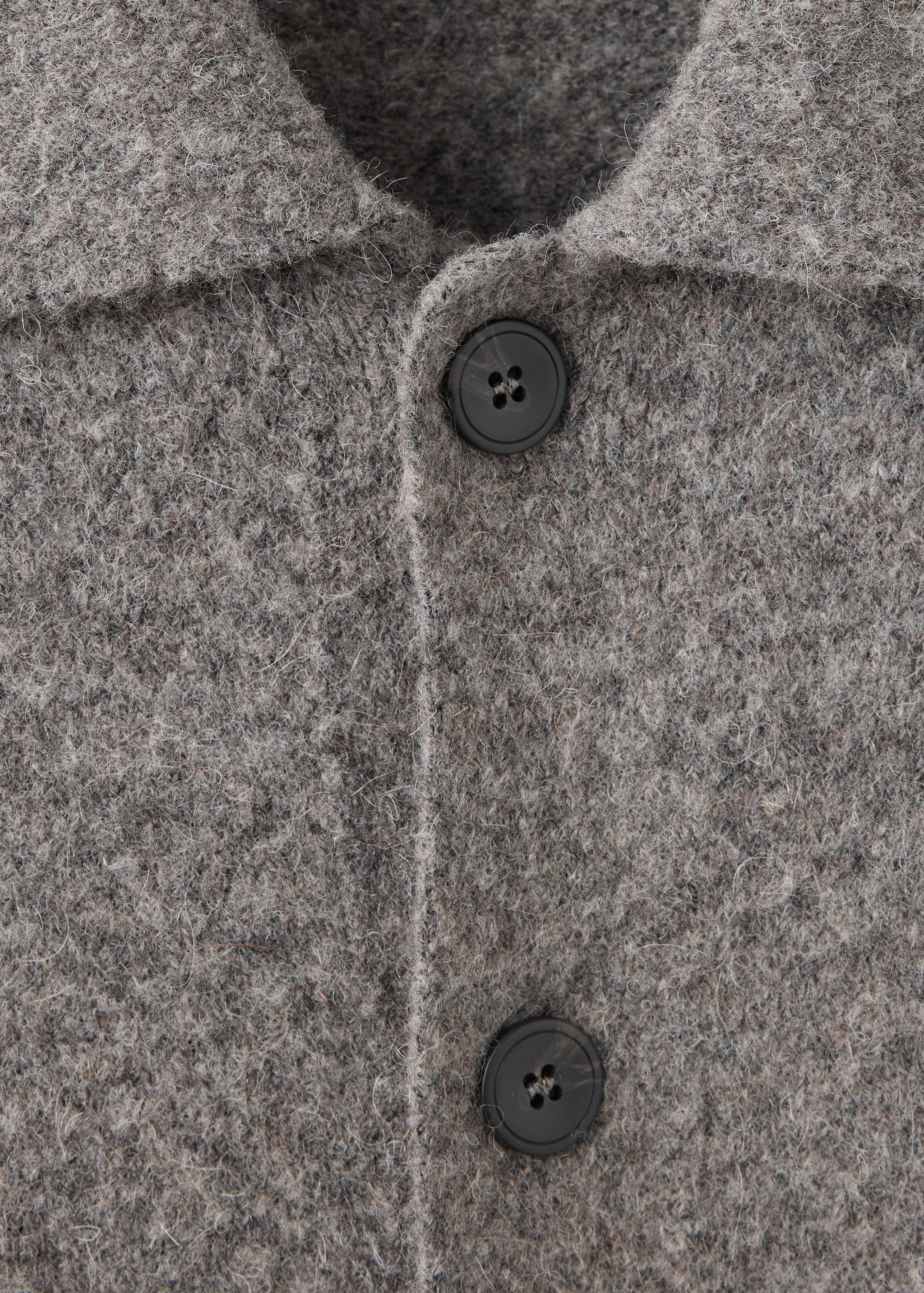 Close-up of a grey heathered shirt with a textured woolen finish and dark buttons.