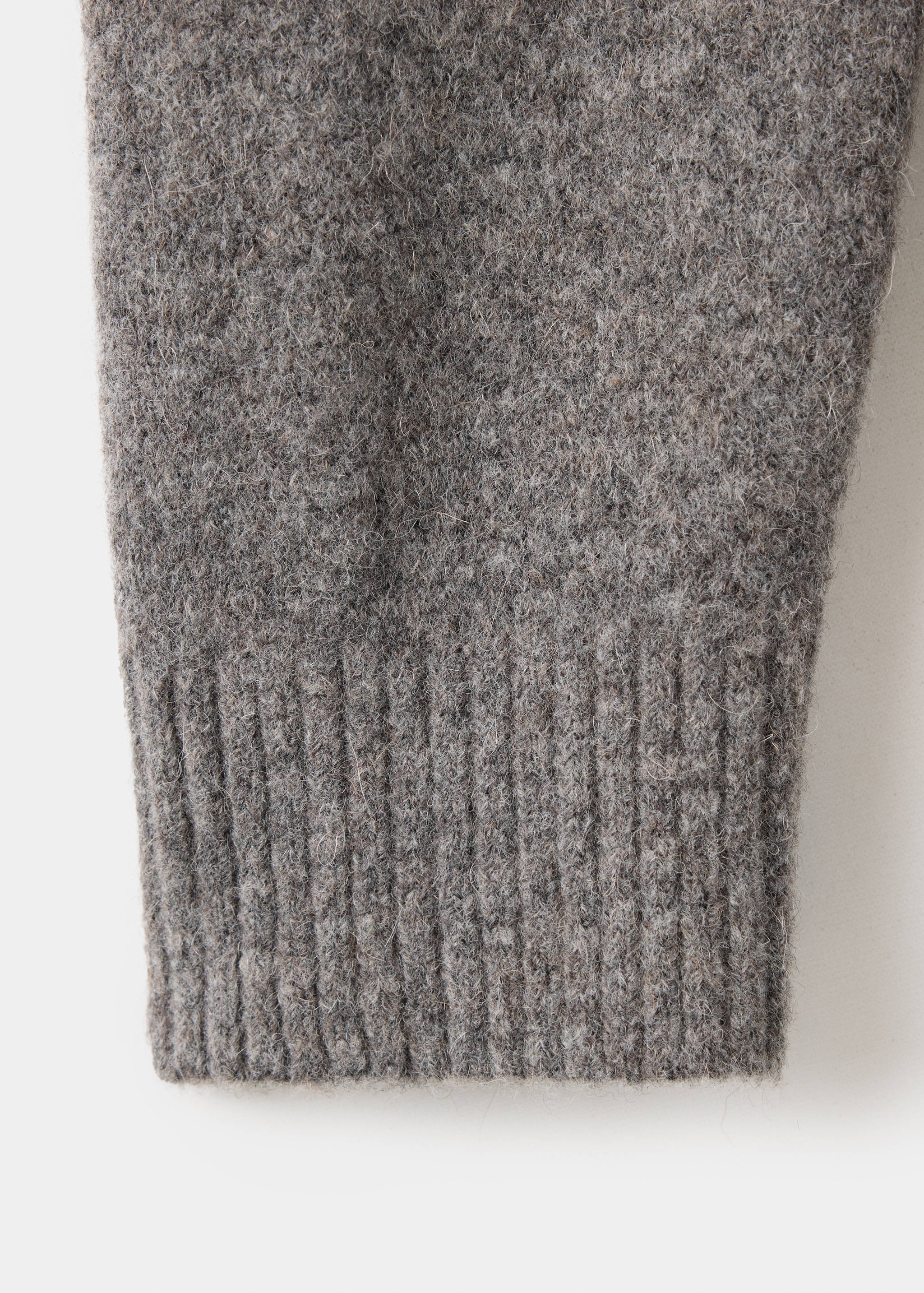 Close-up of a grey melange shirt fabric detail and ribbed cuff.
