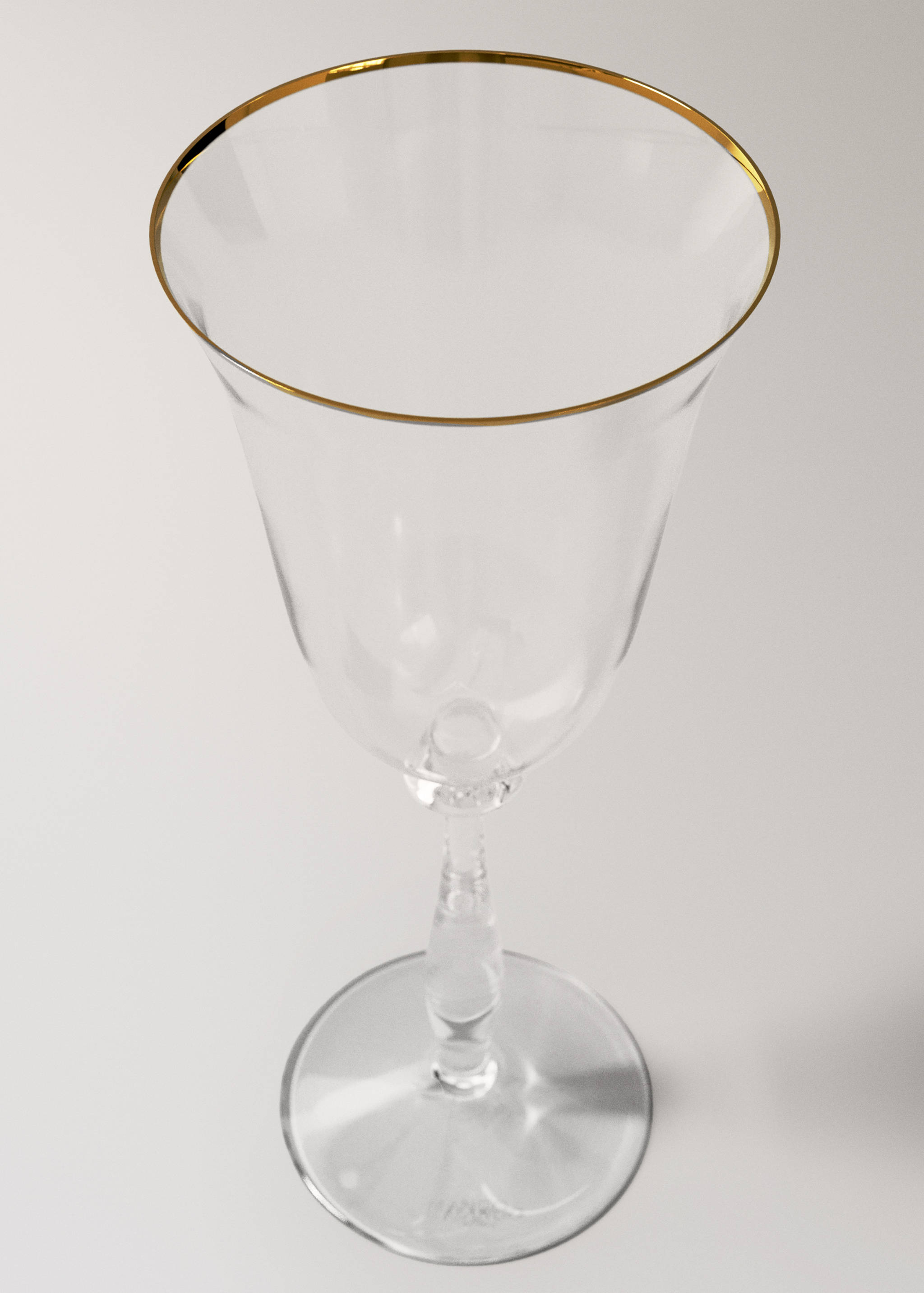 Clear glass goblet with a faceted stem and a metallic gold rim.