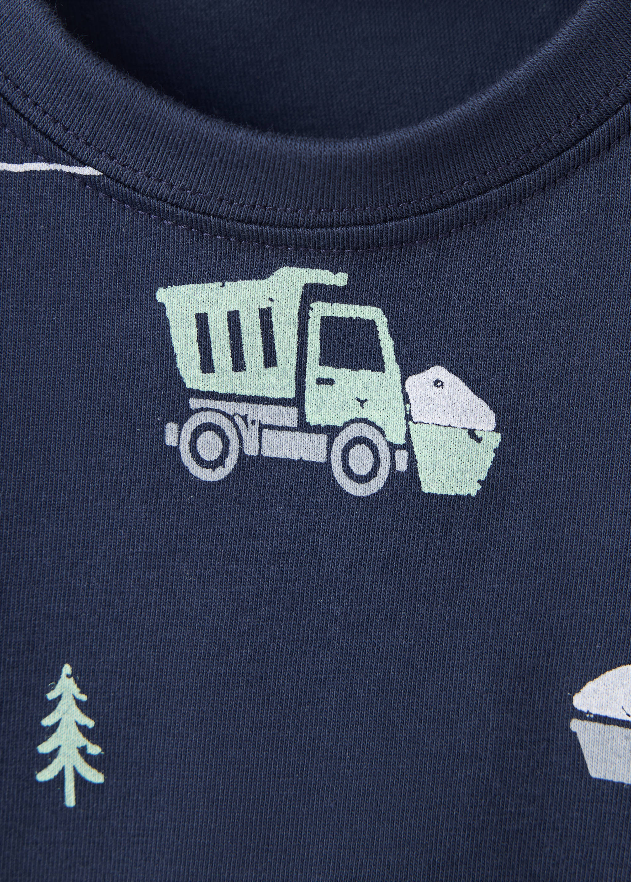 Close-up of a navy blue pyjama top featuring a construction vehicle print and crew neck.