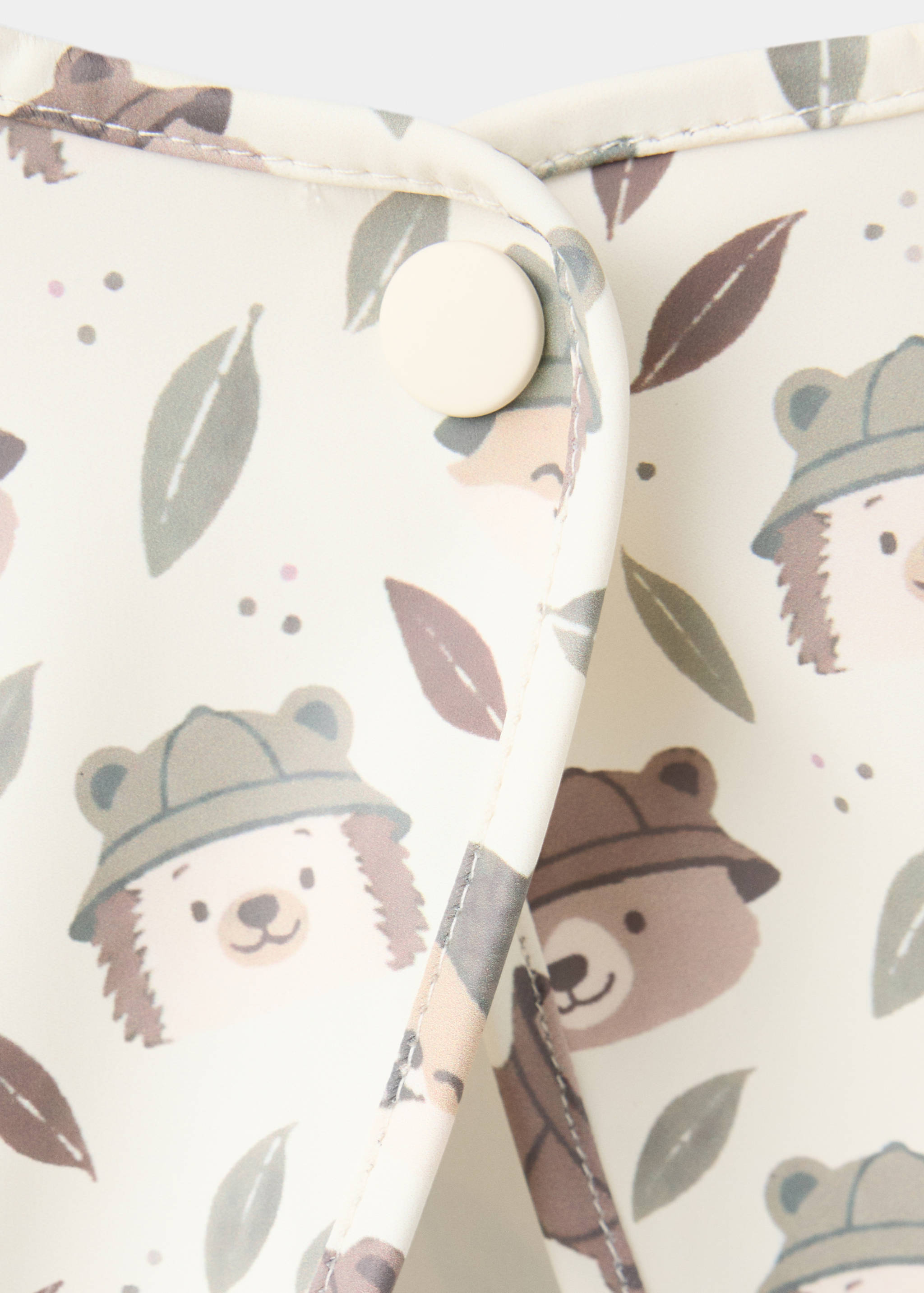 Close-up of a baby bib with a hedgehog print and snap button.