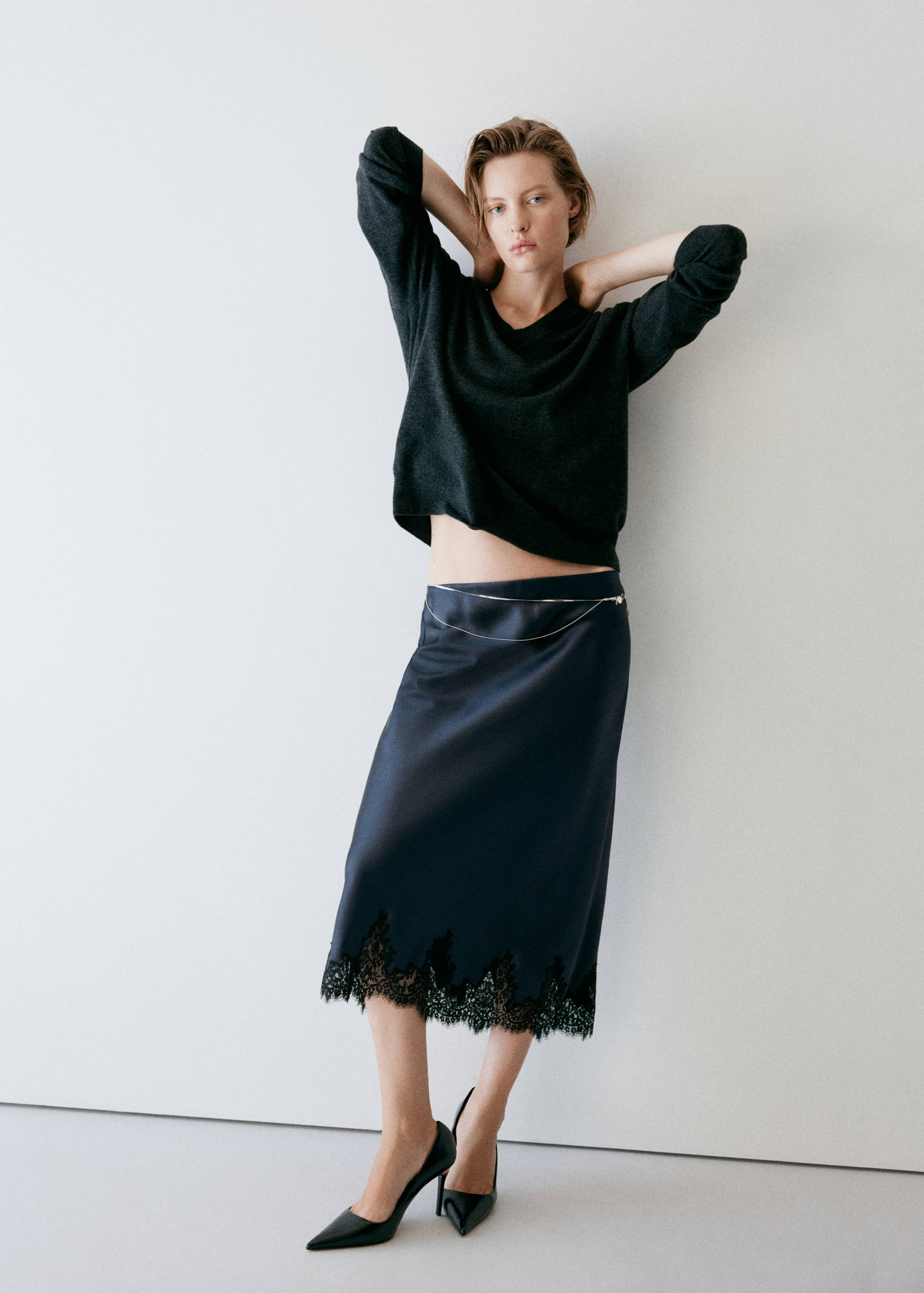 Navy satin midi skirt with black lace trim and chain belt, worn with a dark grey jumper.