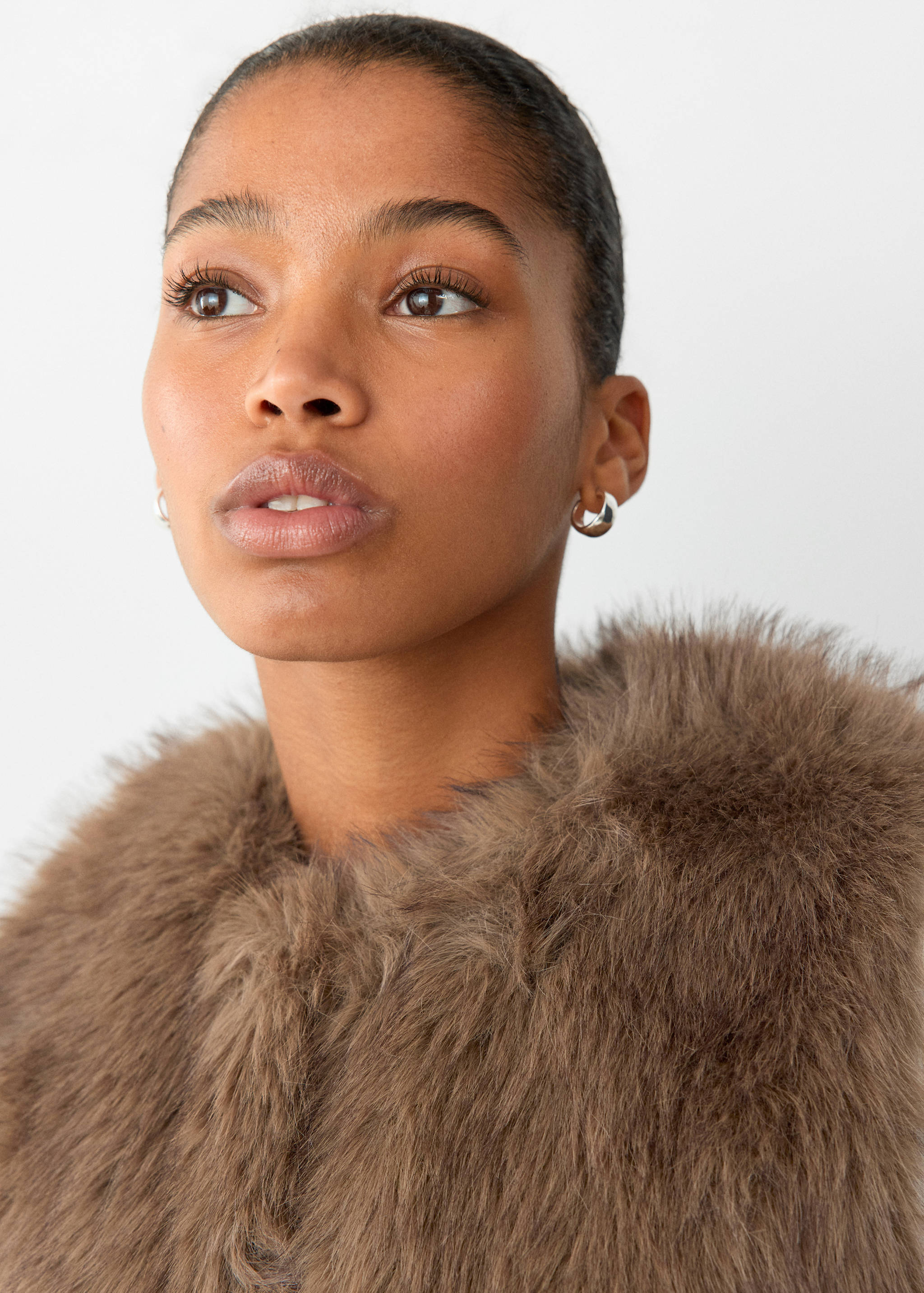 Brown faux-fur vest featuring a fluffy texture and high collar.