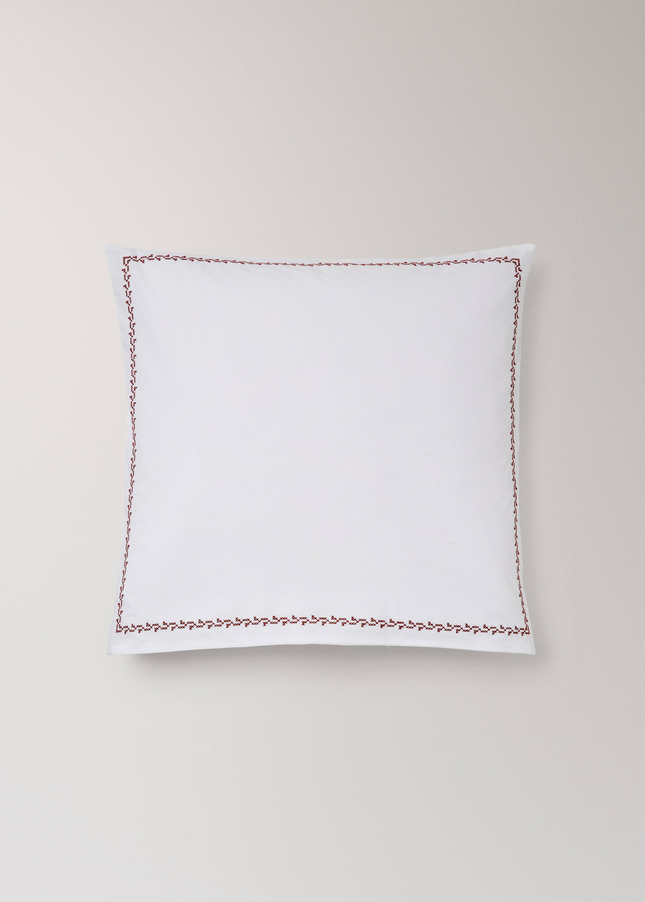 White pillowcase with a dark red embroidered border.