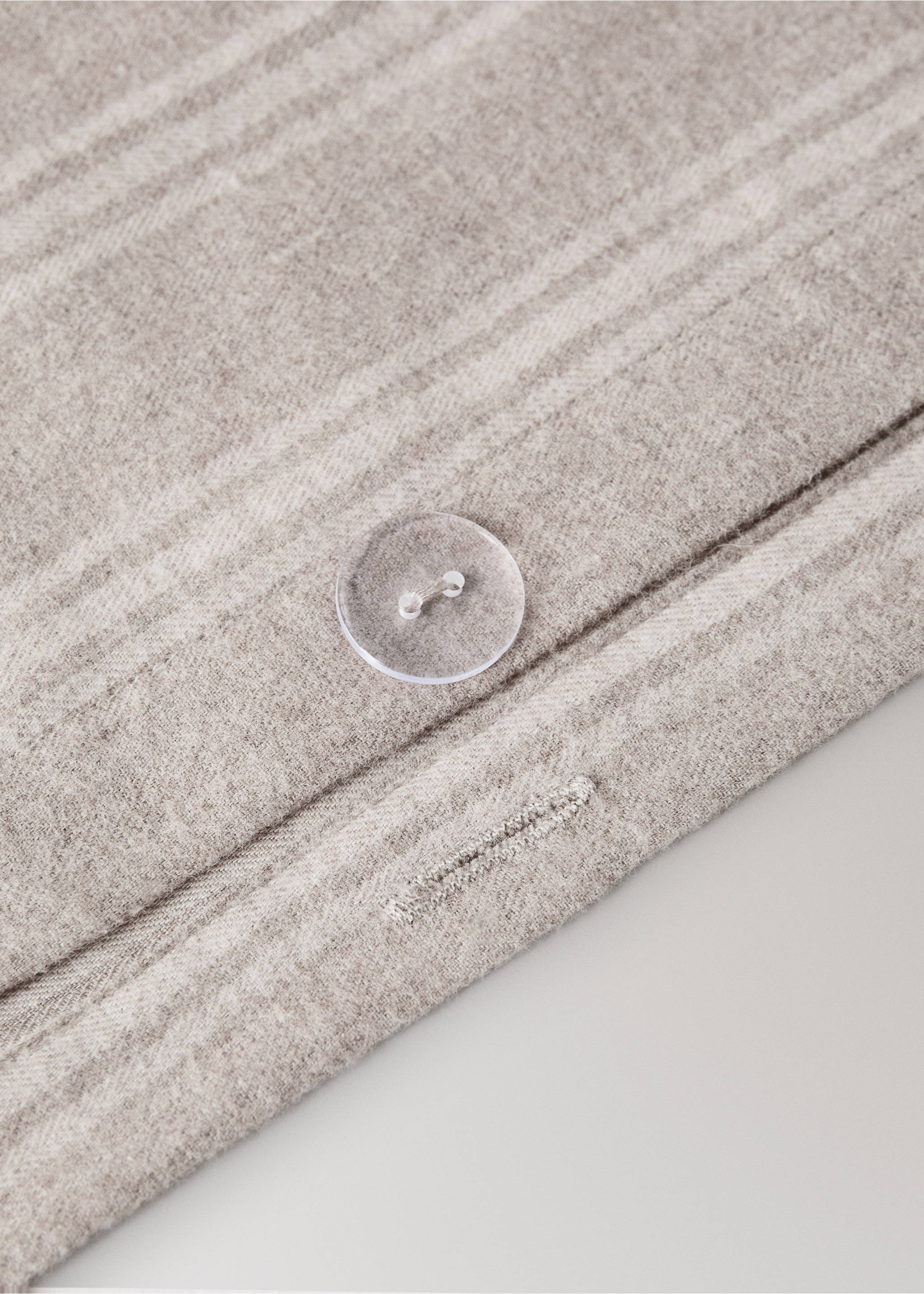 Close-up of a beige textured duvet cover with a button detail., Beige. Ref: 37058266-00.